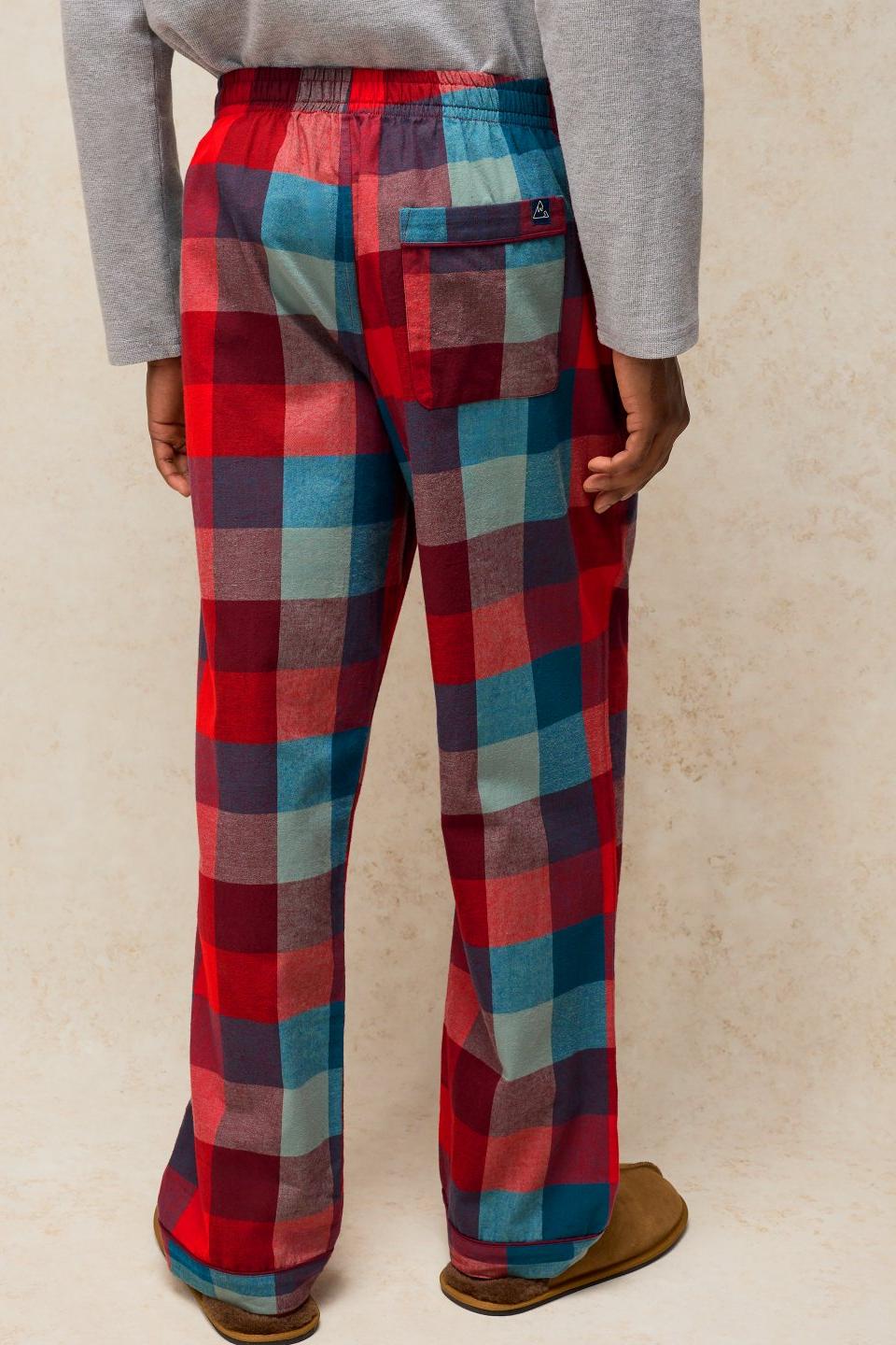 A man wearing red check organic cotton pyjama bottoms with a grey long-sleeved top.