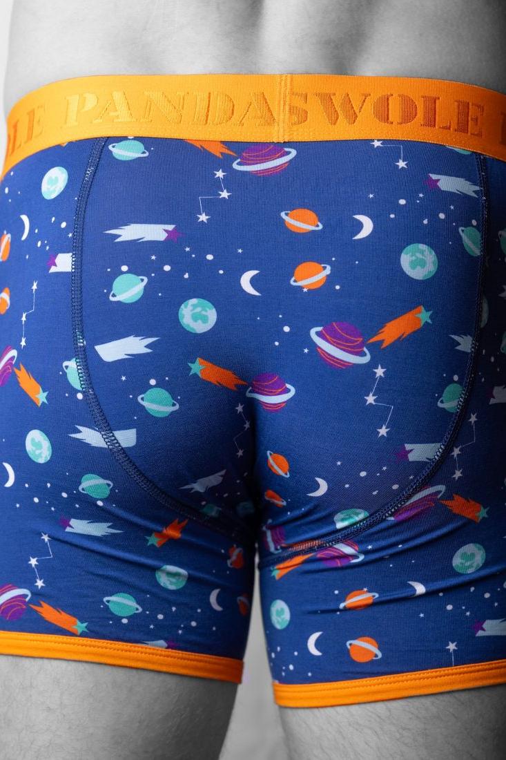 Rear view of a man wearing blue space-themed bamboo boxers with an orange waistband.