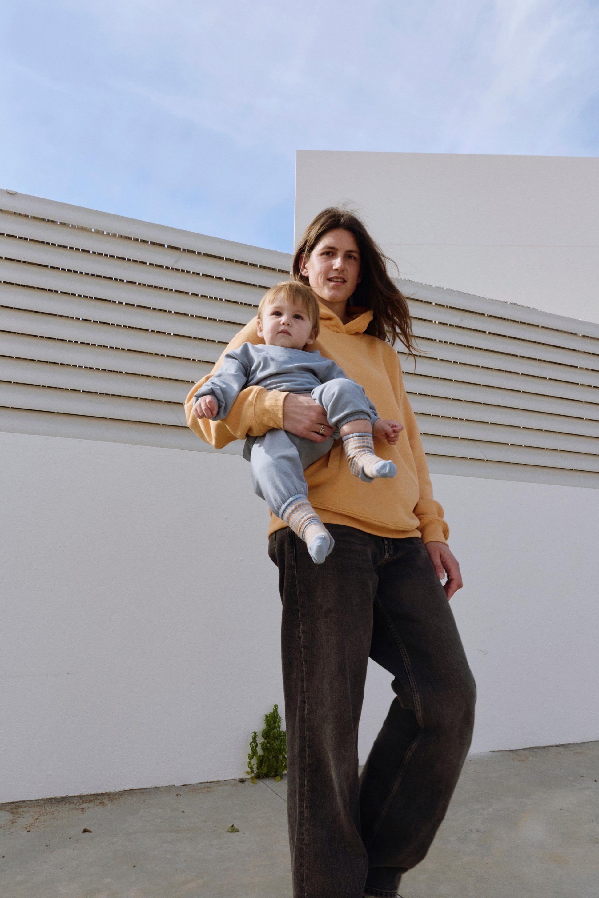 Woman holding a child against a modern architectural background