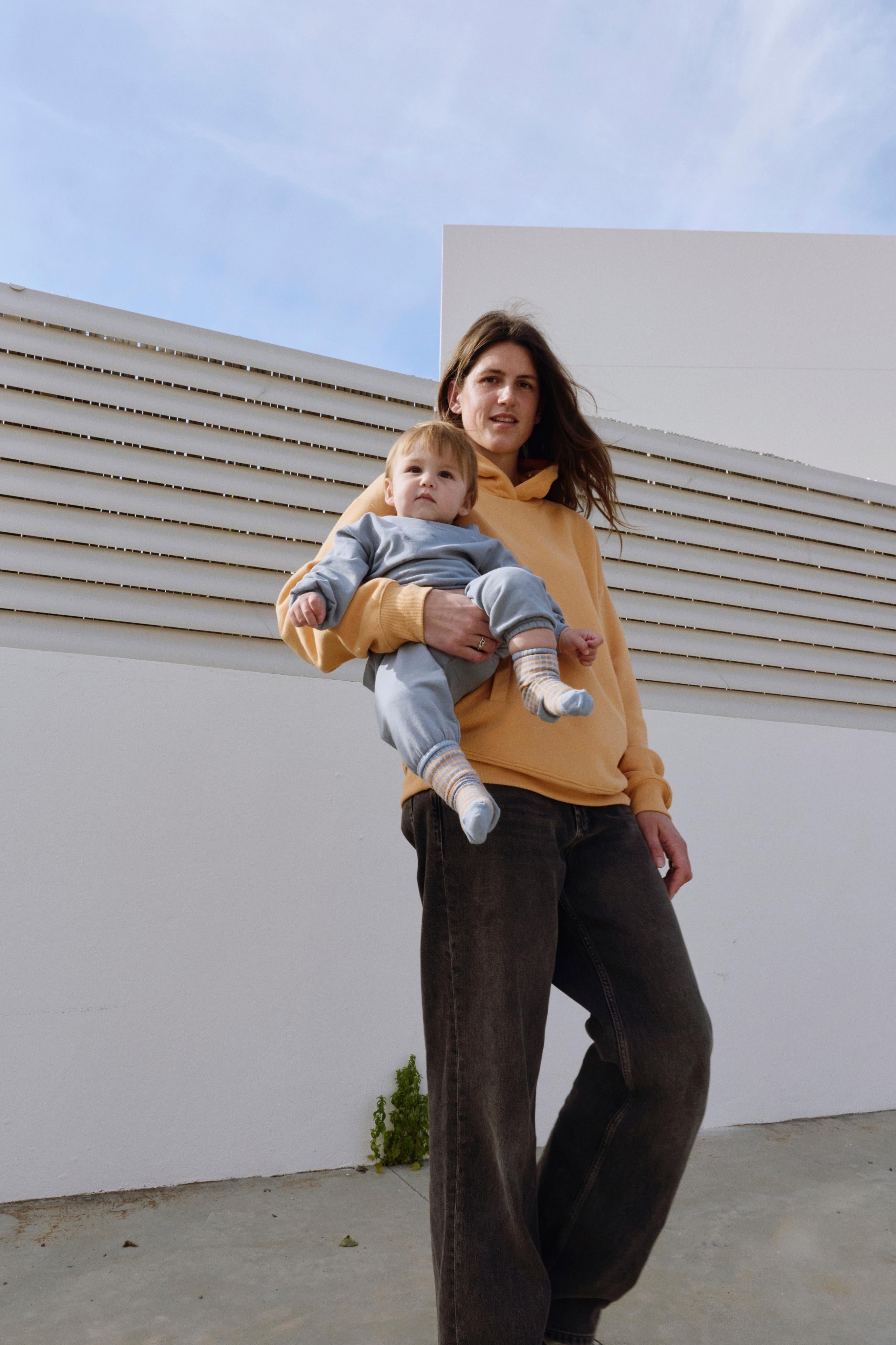 Woman holding a child against a modern architectural background