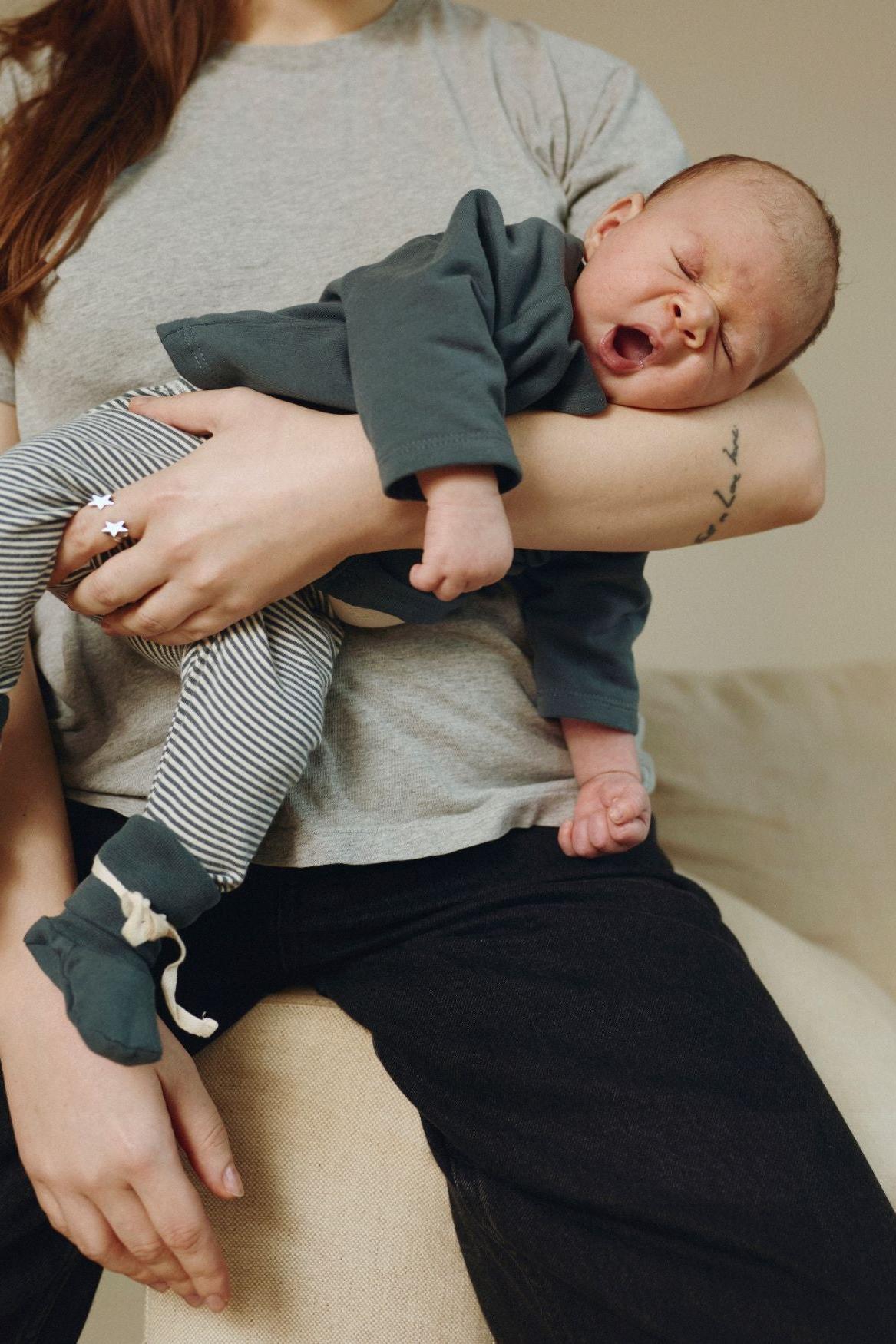 Person holding a baby in a casual setting