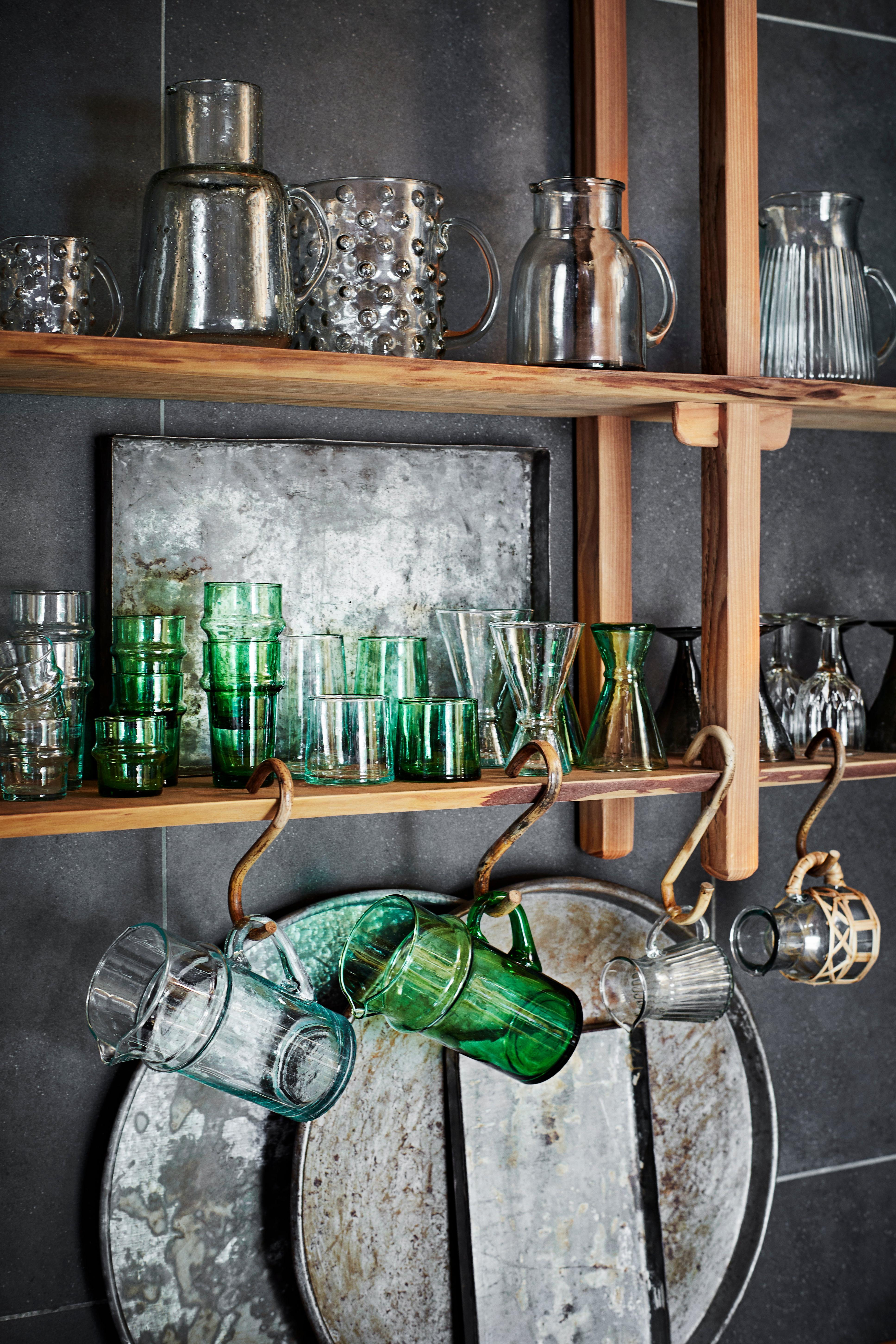 Wooden shelves with various glassware against a dark wall
