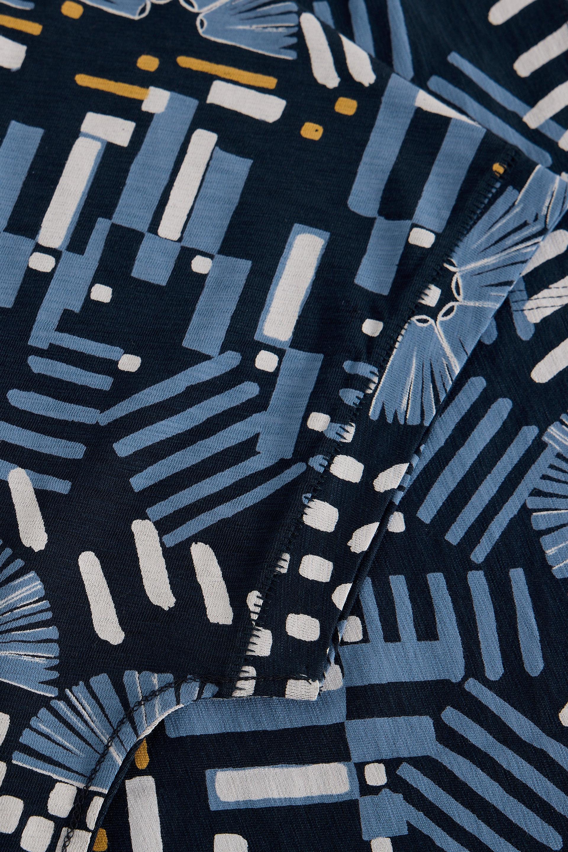 Close-up of navy blue cotton fabric with white and light blue geometric patterns