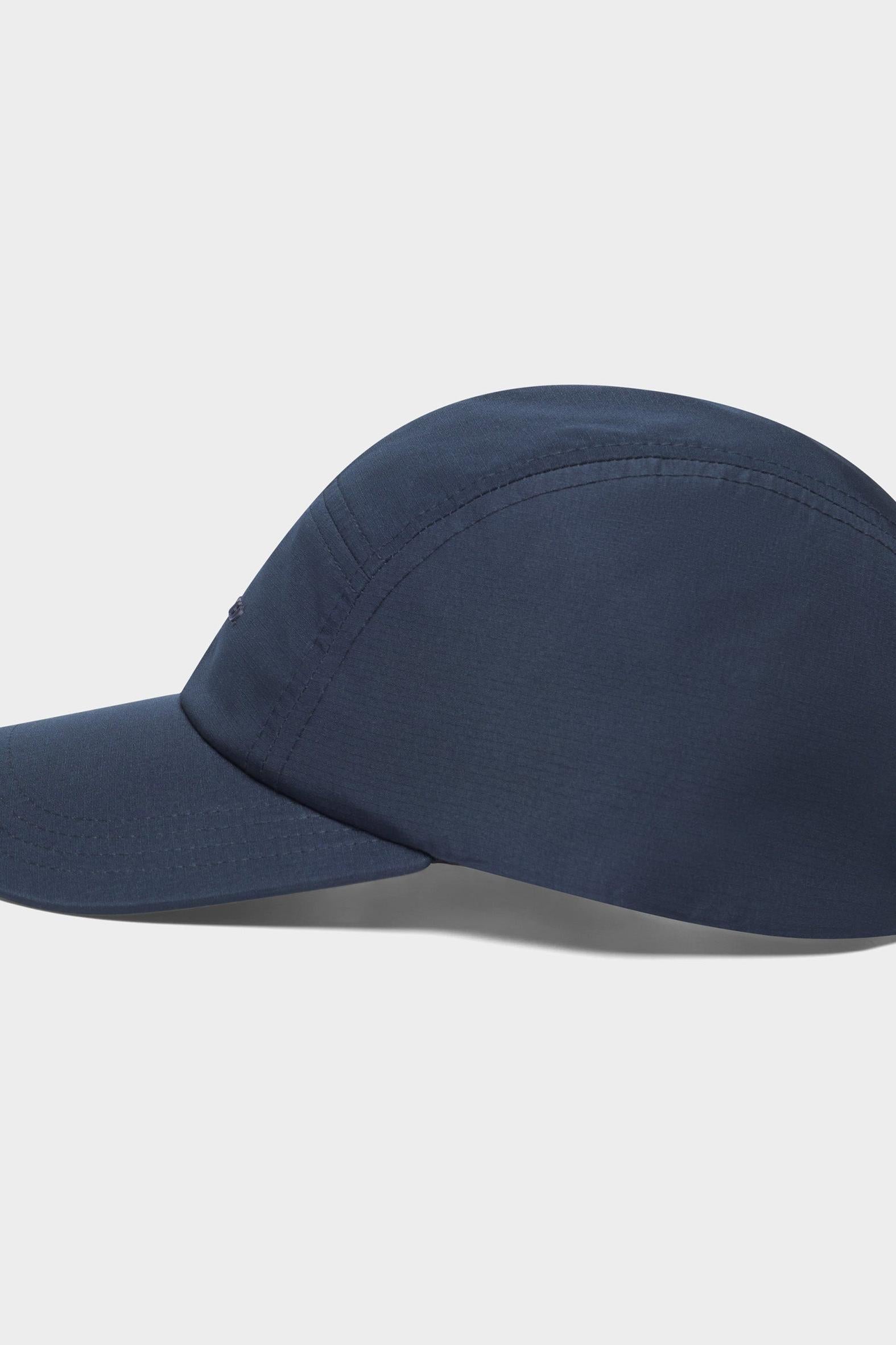 A dark navy blue 5-panel cap with a curved brim, shown from a side profile view against a light gray background.