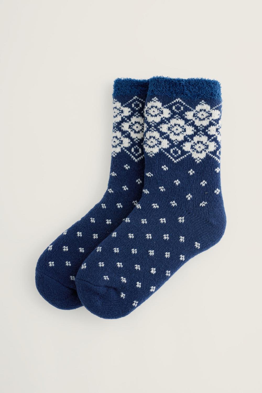 Pair of navy blue fluffy winter socks with a white fairisle floral pattern.
