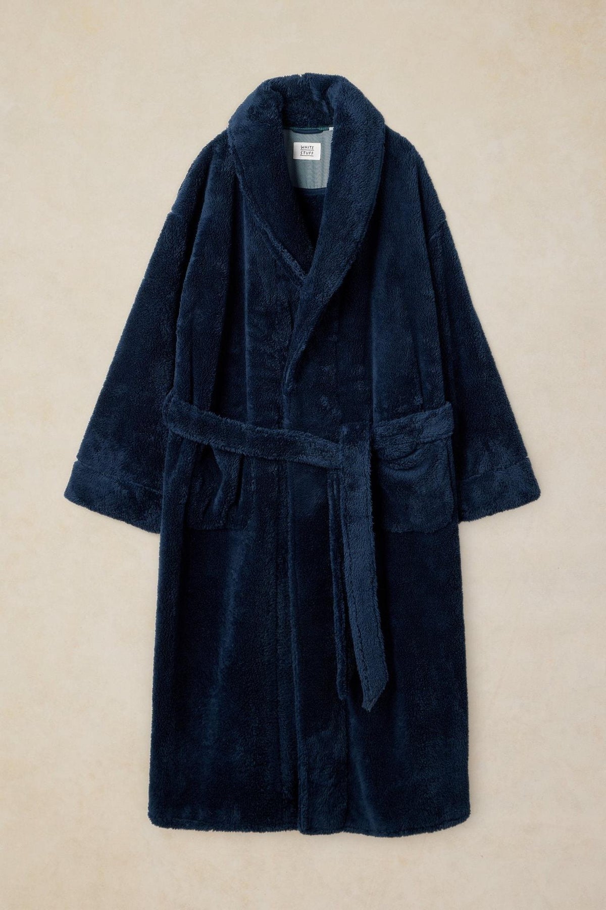 White Stuff navy fluffy men's dressing gown made from recycled polyester against a neutral background.