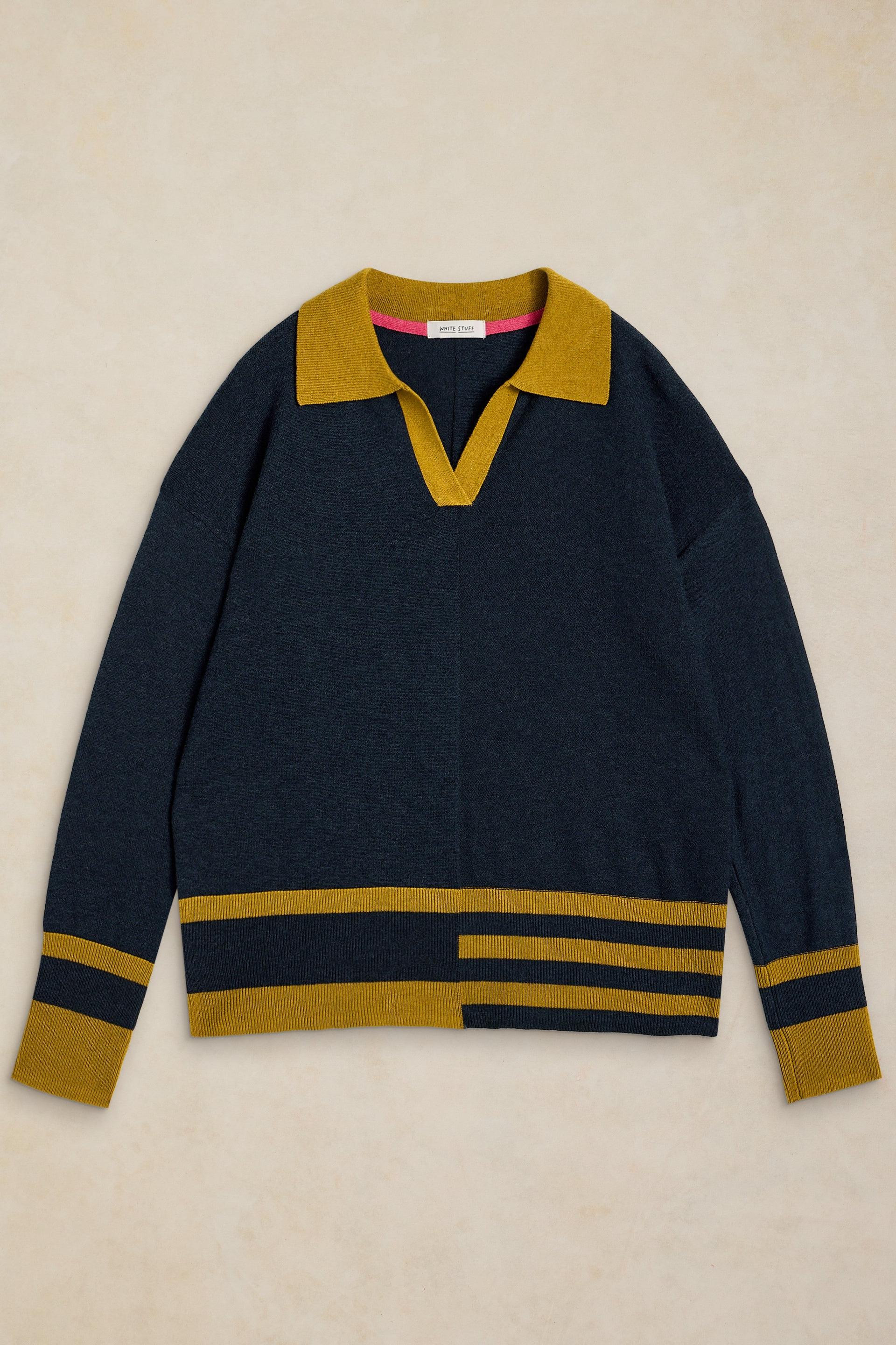 A navy blue knit sweater with mustard yellow accents, featuring a V-neck collar, a split V-neckline, and horizontal stripe details on the cuffs and hem, laid flat against a light beige textured background.