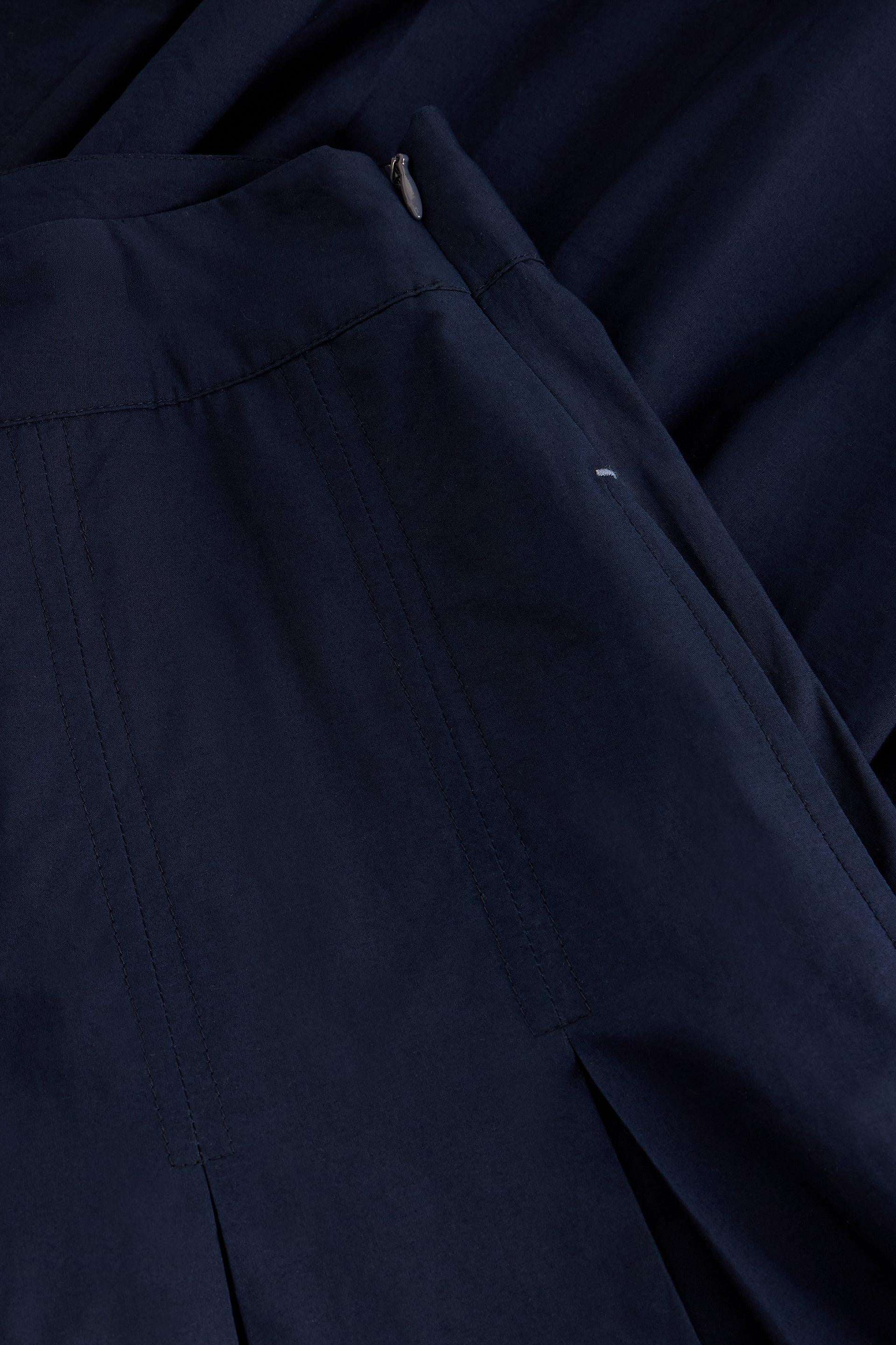 Close-up of a navy blue organic cotton skirt showing detailed stitching and side zipper
