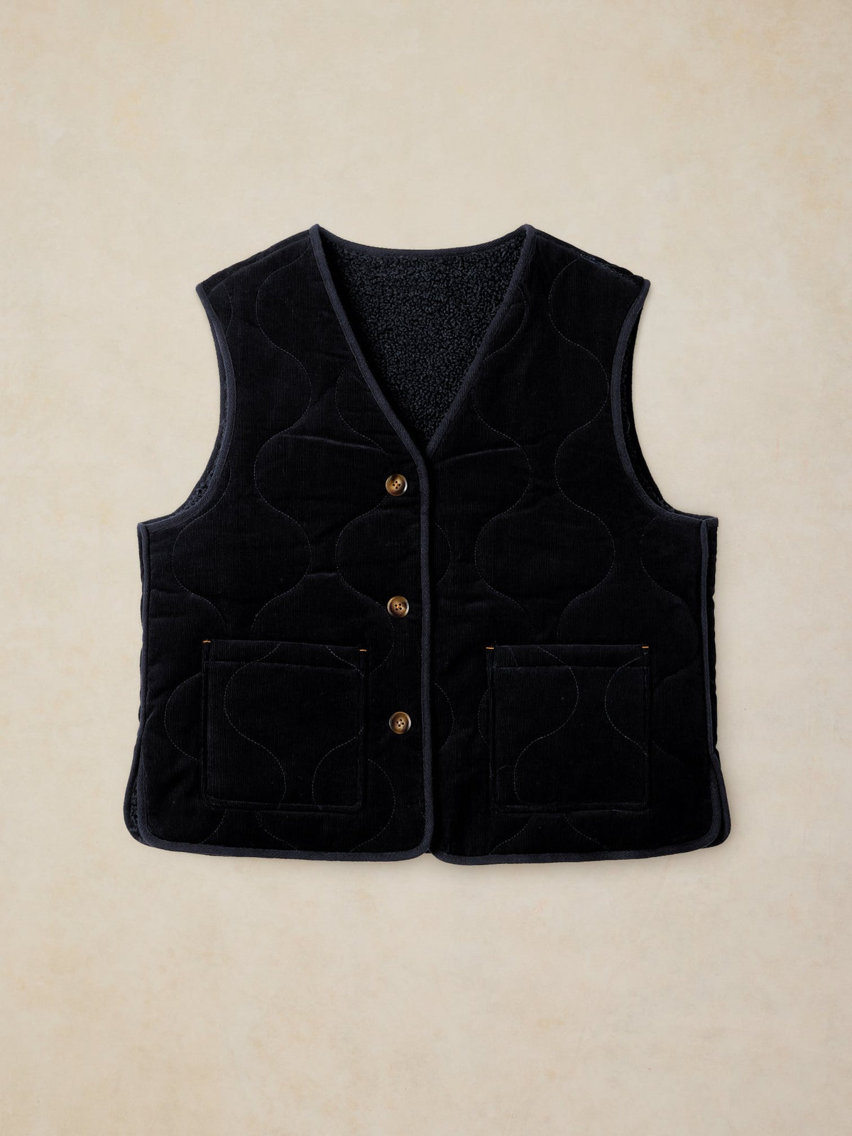 A navy reversible gilet by White Stuff featuring a quilted corduroy exterior and button-down front.