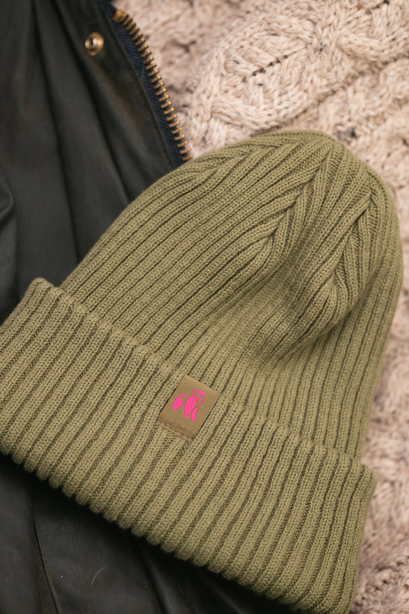 Swole Panda olive green organic cotton beanie hat with a pink logo patch.