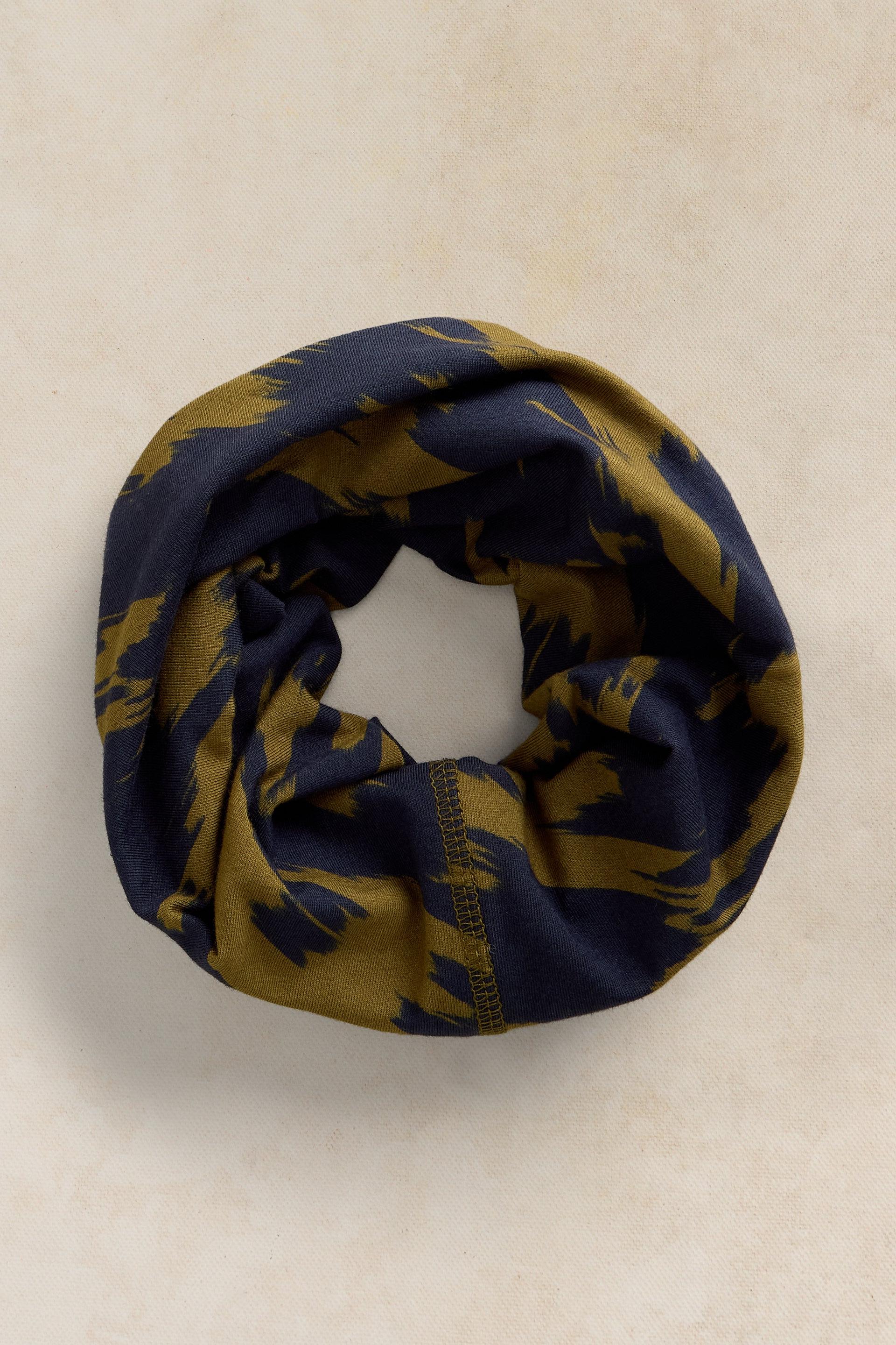 A circular neck gaiter with a navy blue and olive green camouflage pattern on a neutral background