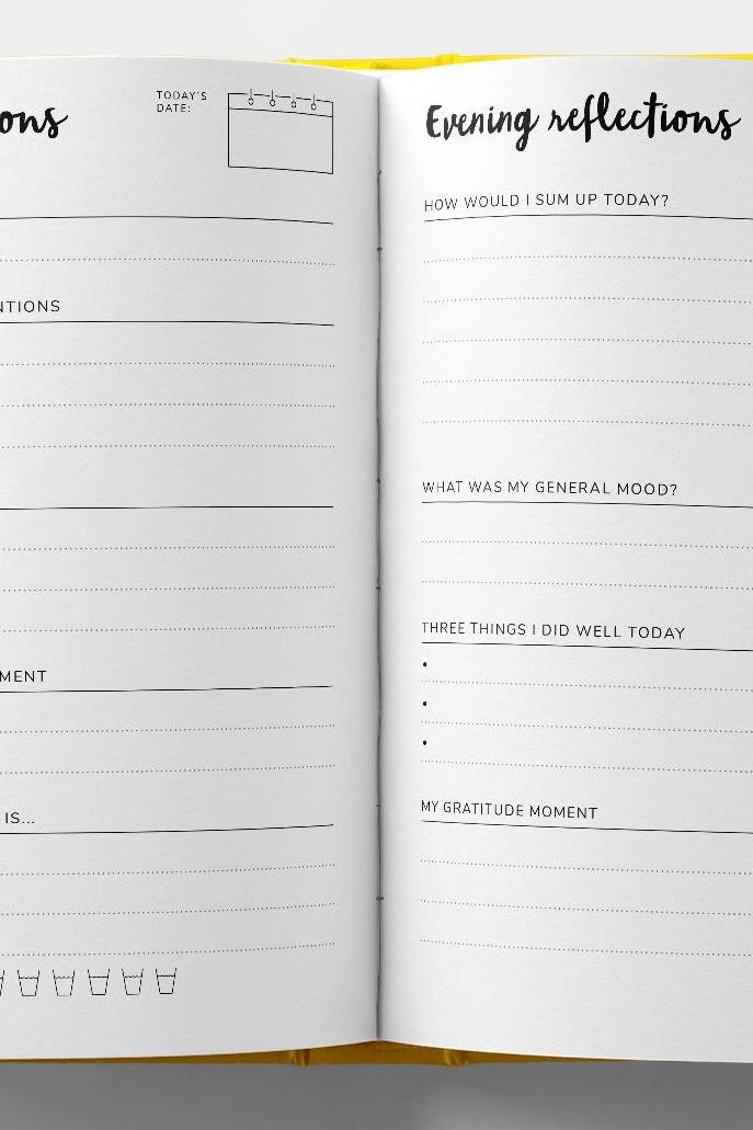 An open mindfulness journal showing pages for daily intentions and evening reflections with sections for self care.