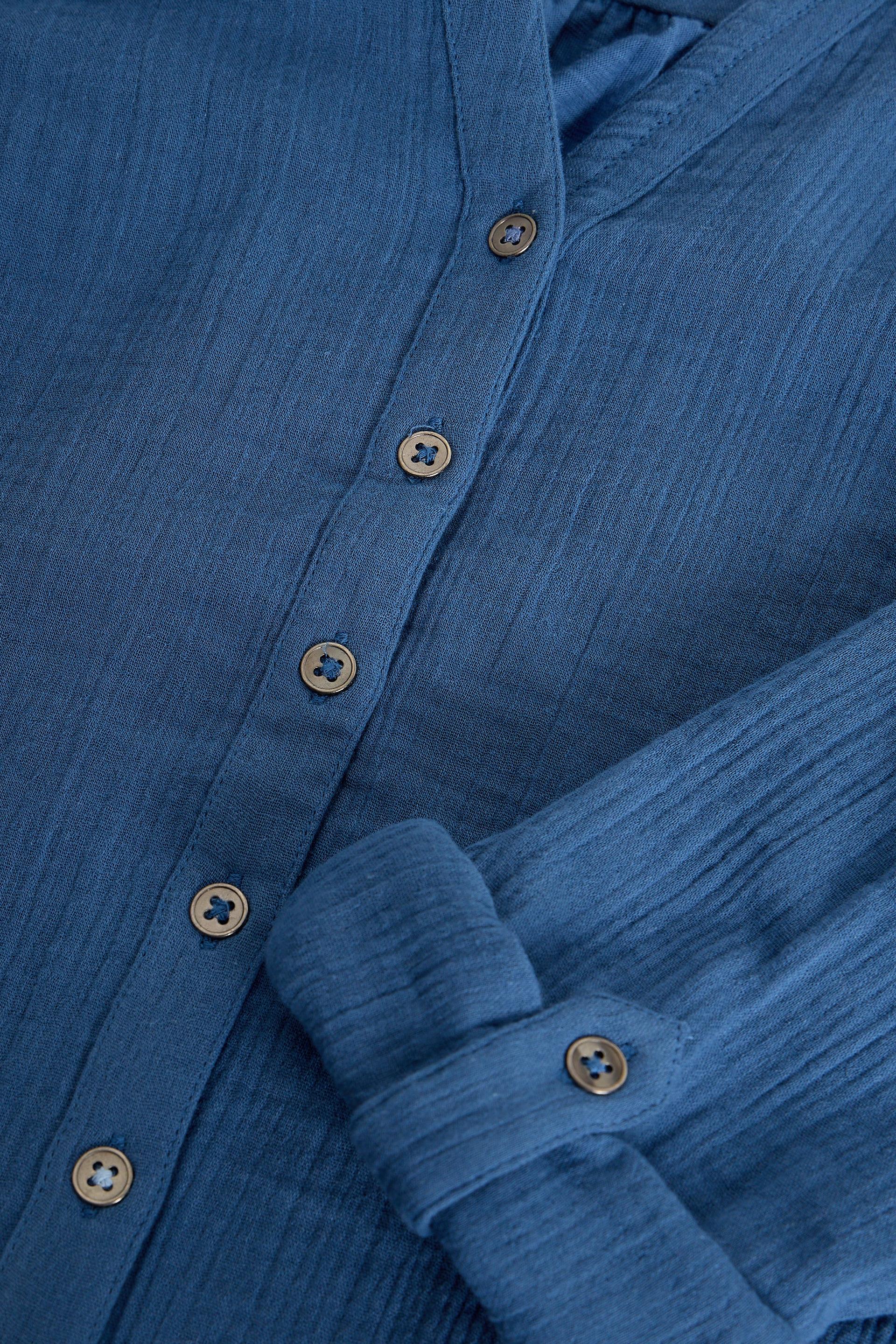 Close-up of a blue textured shirt with buttons