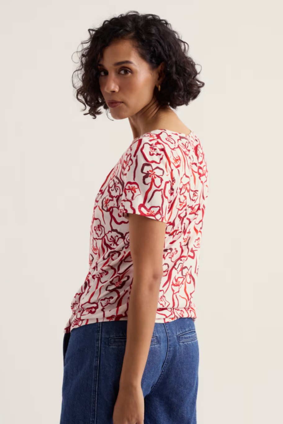 Woman wearing a red and white patterned shirt on a plain background