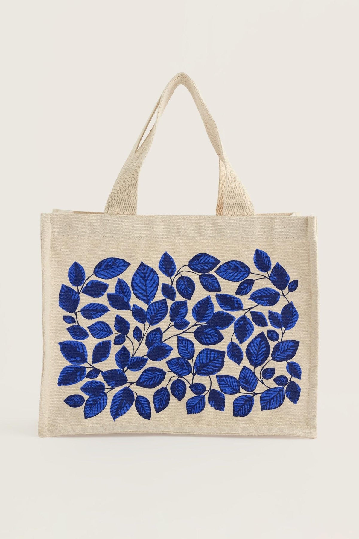 Seasalt Cornwall organic cotton canvas shopping bag featuring a blue leaf print against a cream background.