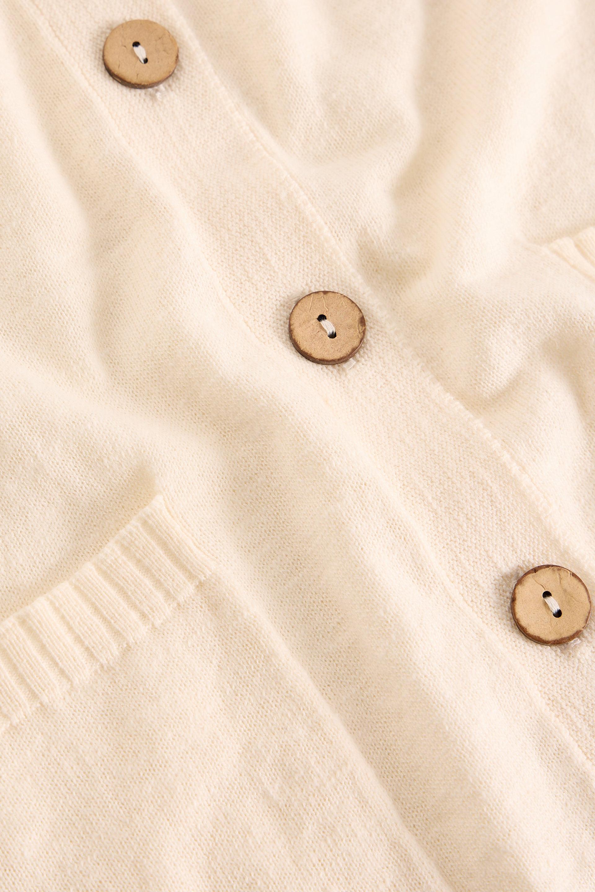 Close-up of a beige textured fabric with wooden buttons