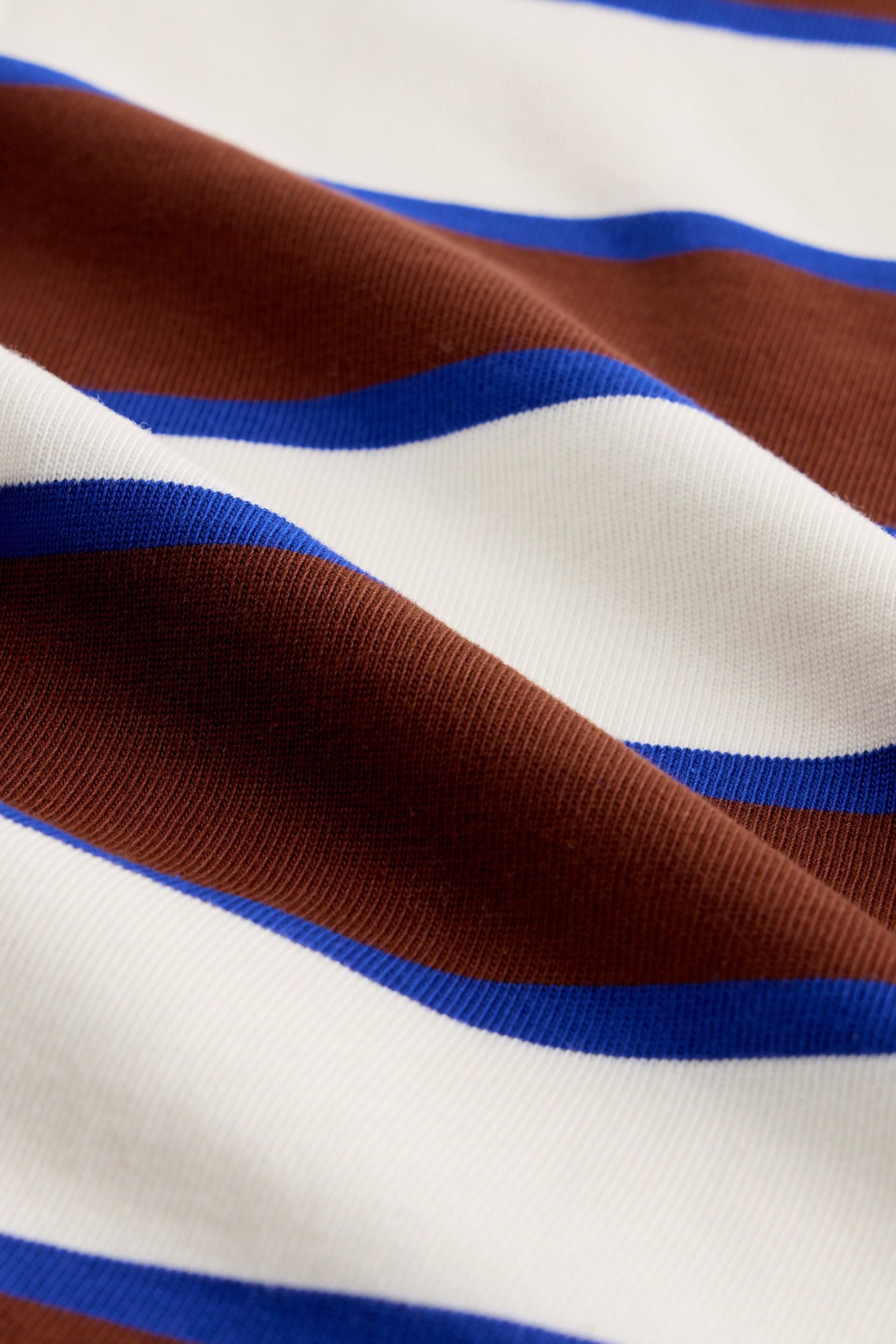 Close-up of soft organic cotton fabric with brown, white, and blue stripes.
