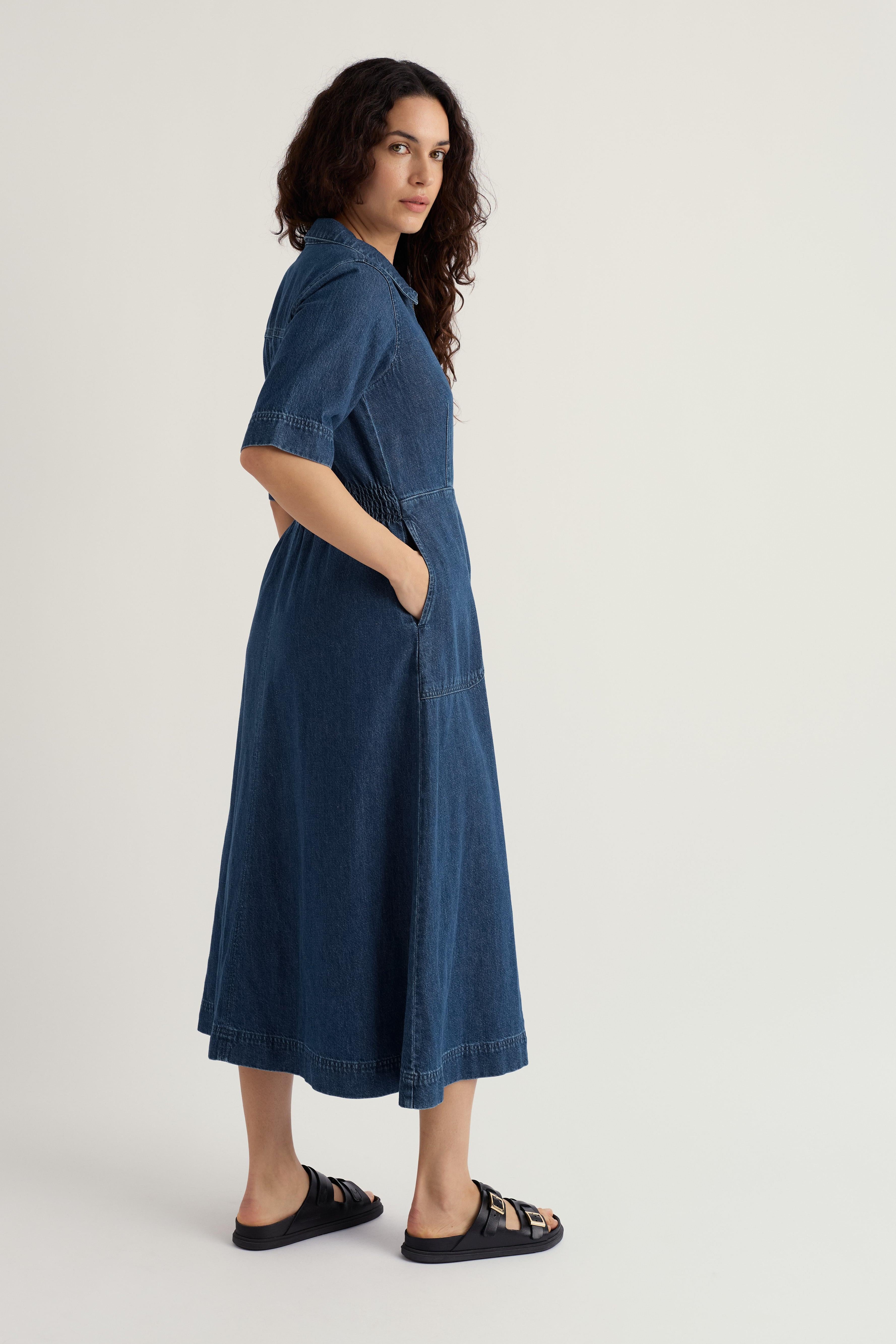 Woman wearing a blue organic cotton denim dress on a white background