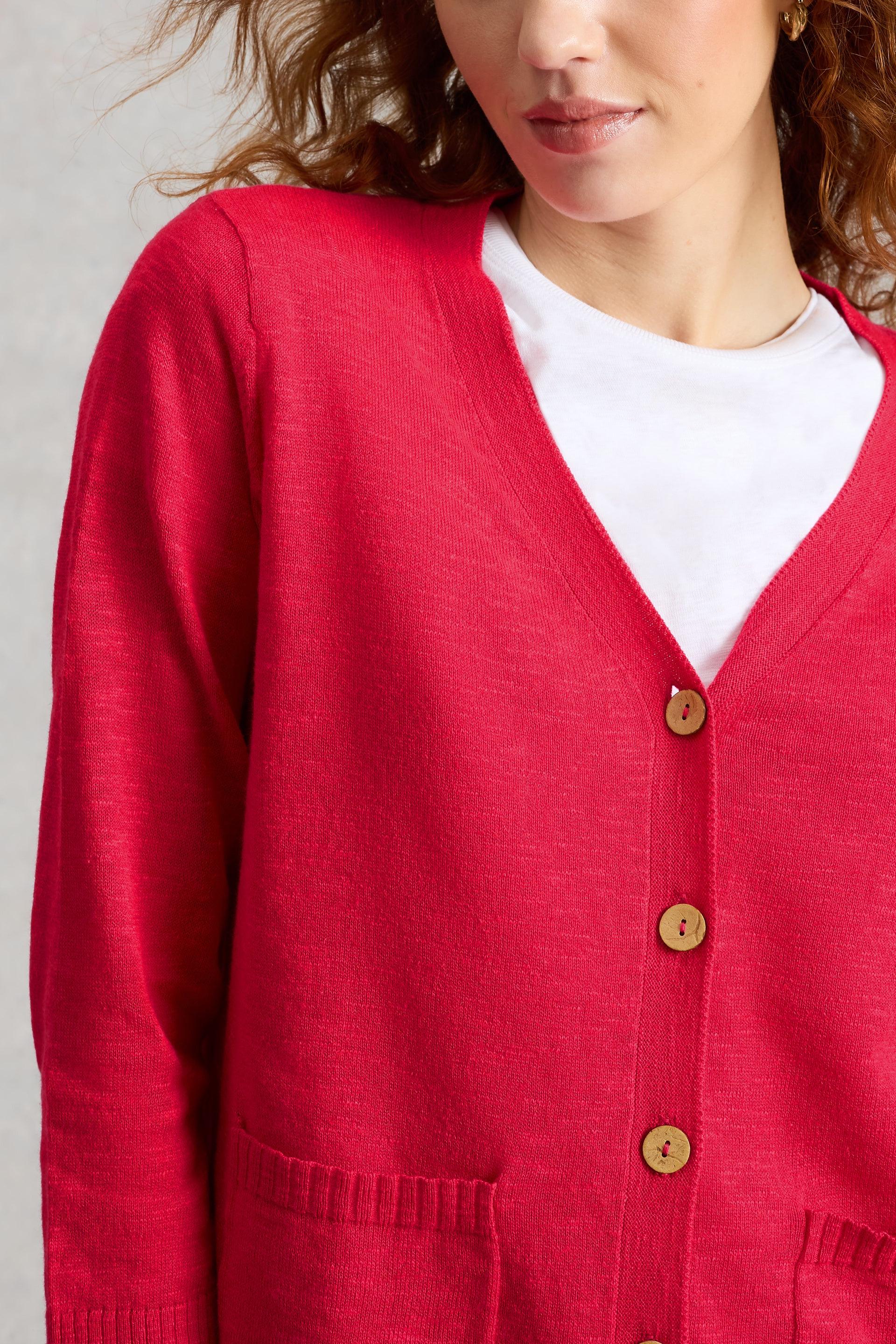 Pink White Stuff cardigan with wooden buttons worn by a model on a light gray background