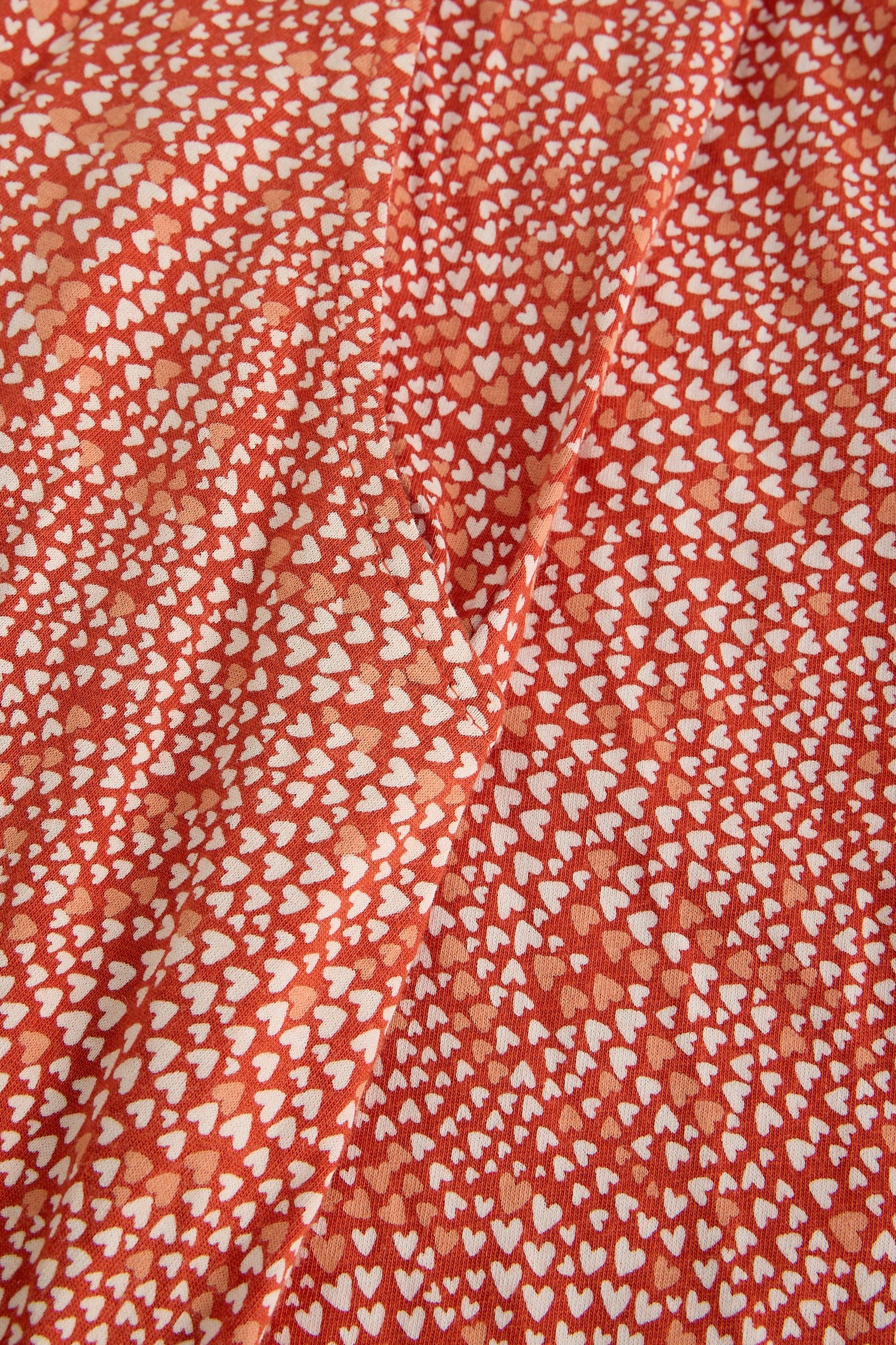 Red organic cotton fabric with small white heart pattern