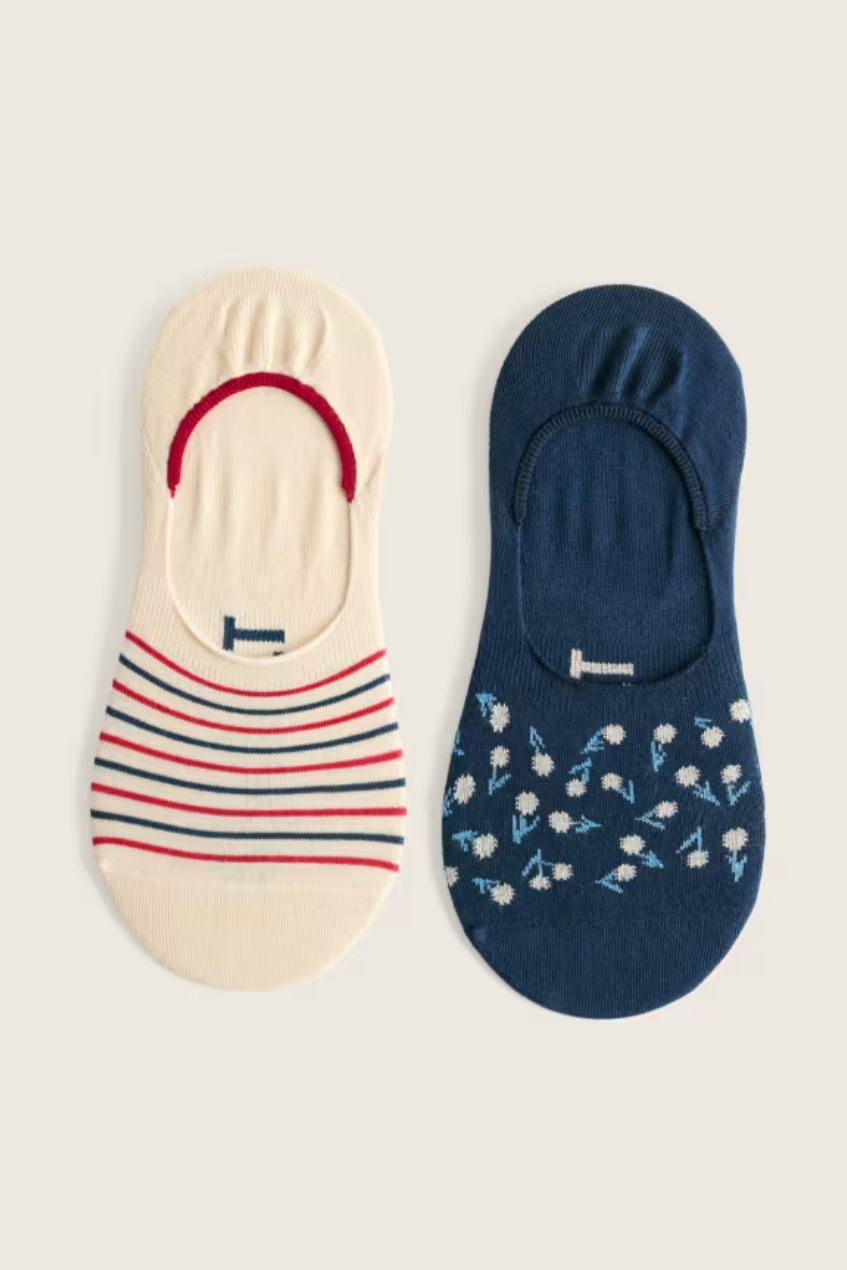 A pair of no-show socks, one cream with stripes and one navy with small floral patterns.