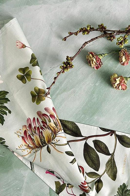 Floral-patterned tea towel with a branch of flowers on a light green background