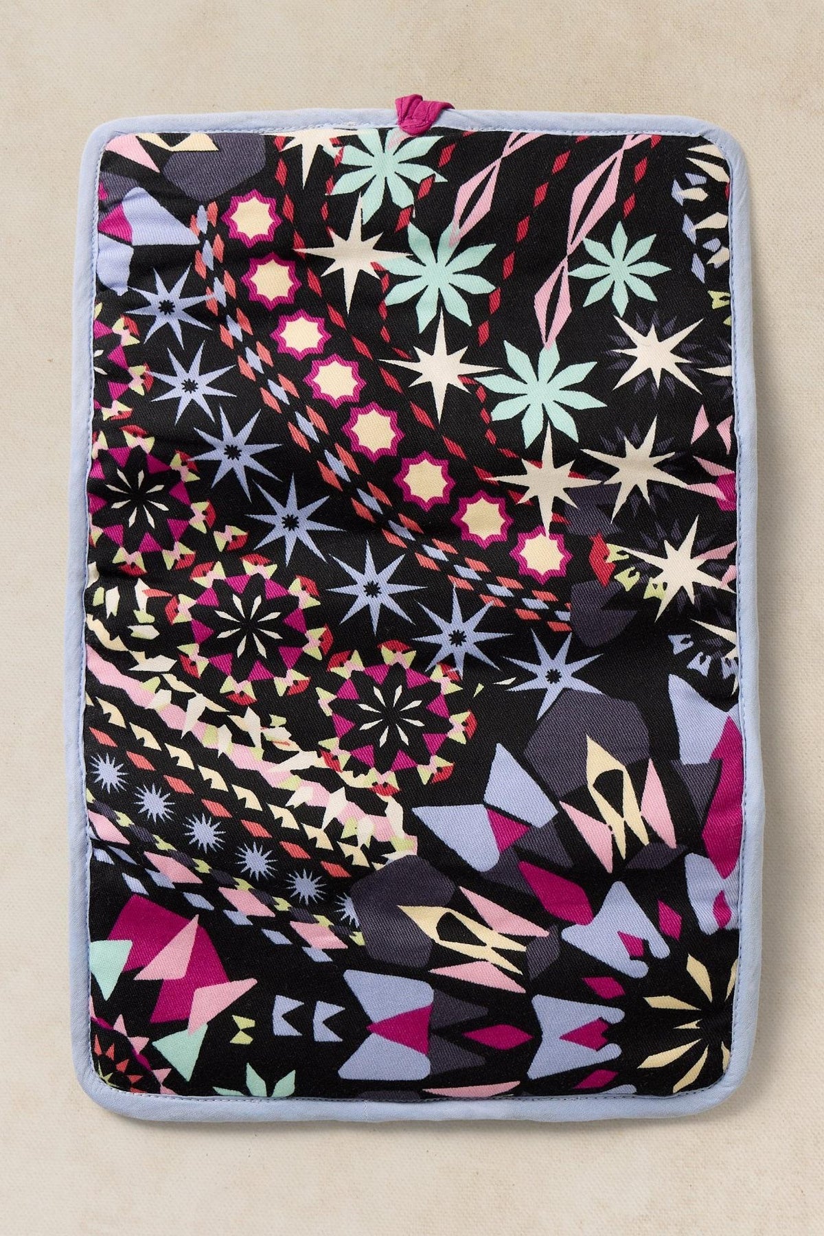 Rectangular fabric jewellery organiser with a black, multi-colored star and geometric pattern.