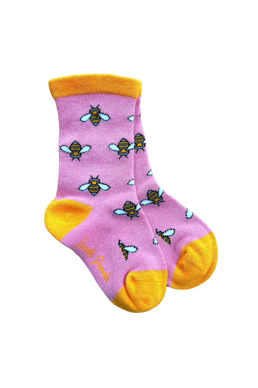 A pair of pink crew socks made from bamboo fiber featuring a repeating yellow and black bee print.