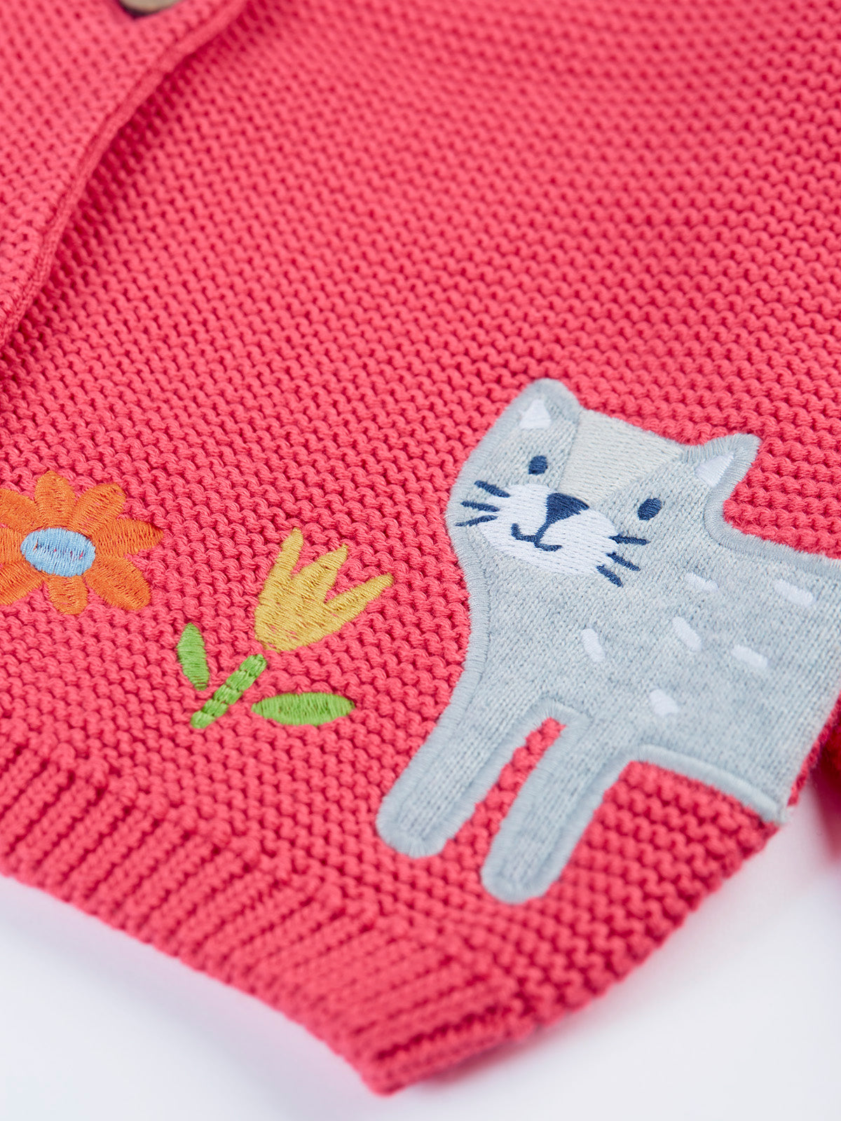 Pink organic cotton girls cardigan with embroidered cat and flower designs.