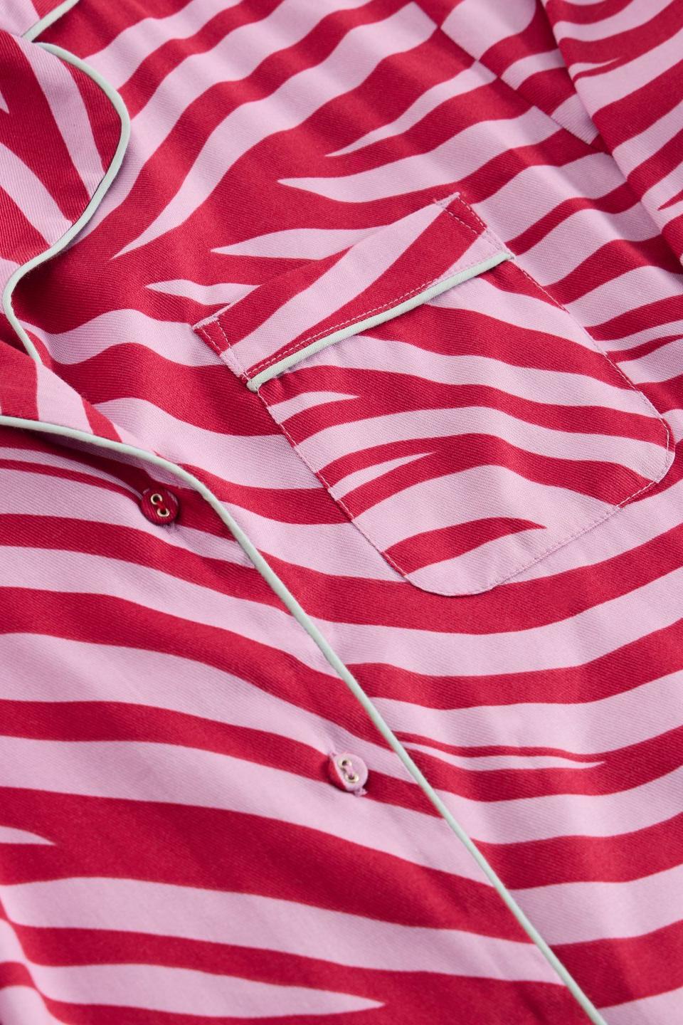 Close-up of a pink zebra print organic cotton pyjama top with a button-down front and chest pocket.