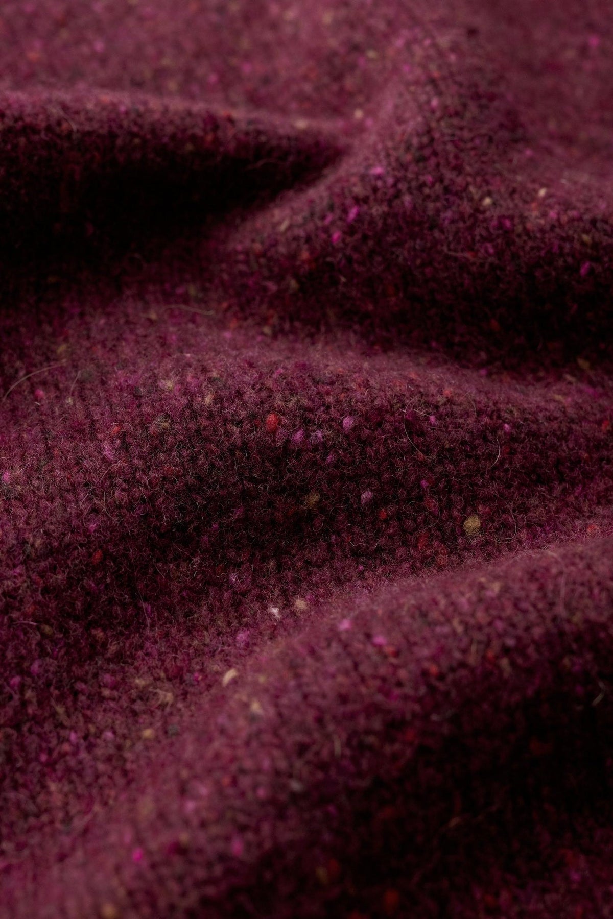 Close up fabric texture of a plum merino wool jumper