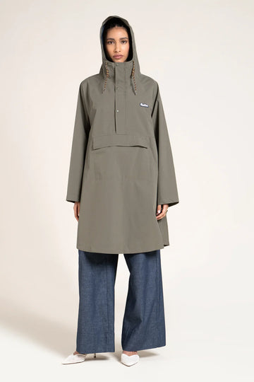 Person wearing a long green raincoat with a hood on a white background