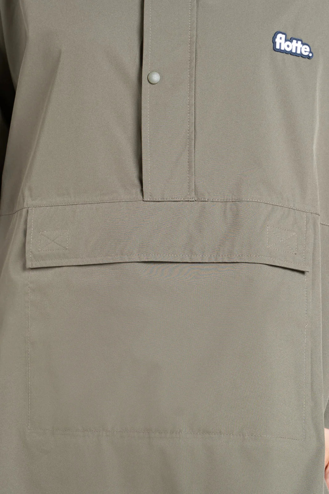 Close-up of green Flotte jacket with a visible logo and a front pouch pocket
