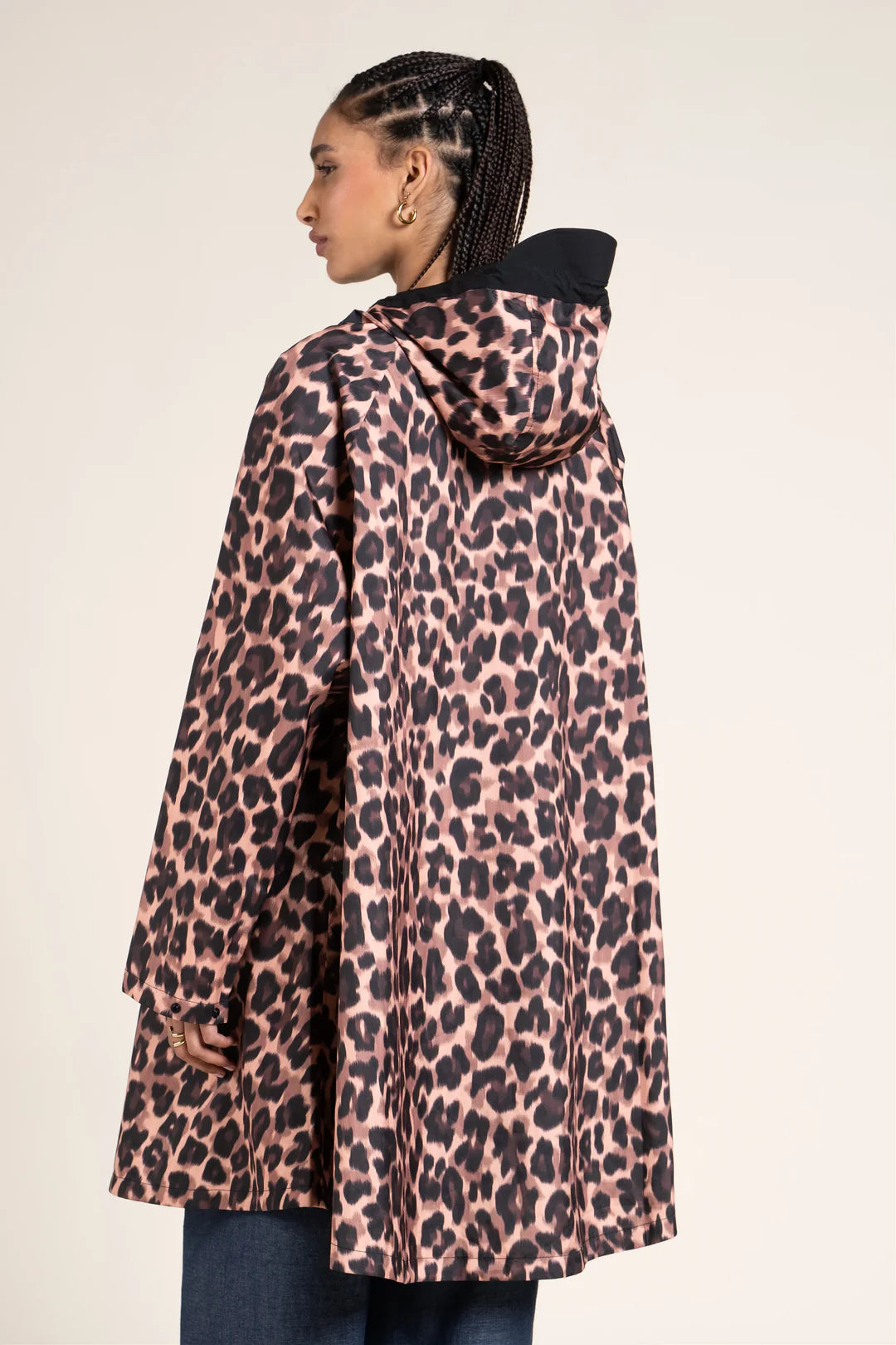 Person wearing a leopard print Flotte coat on a plain background