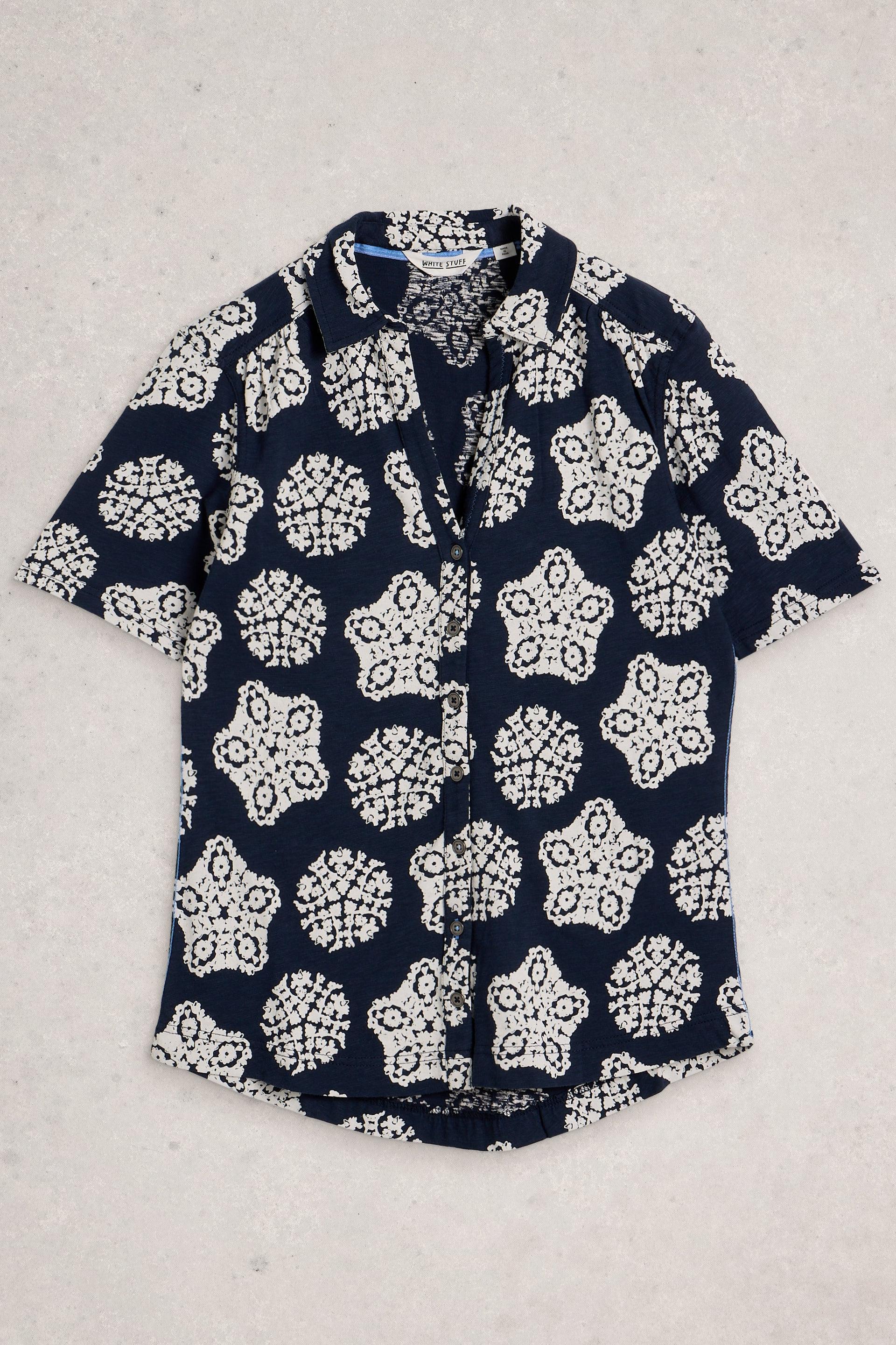 Navy blue White Stuff shirt with white floral pattern on a light gray background