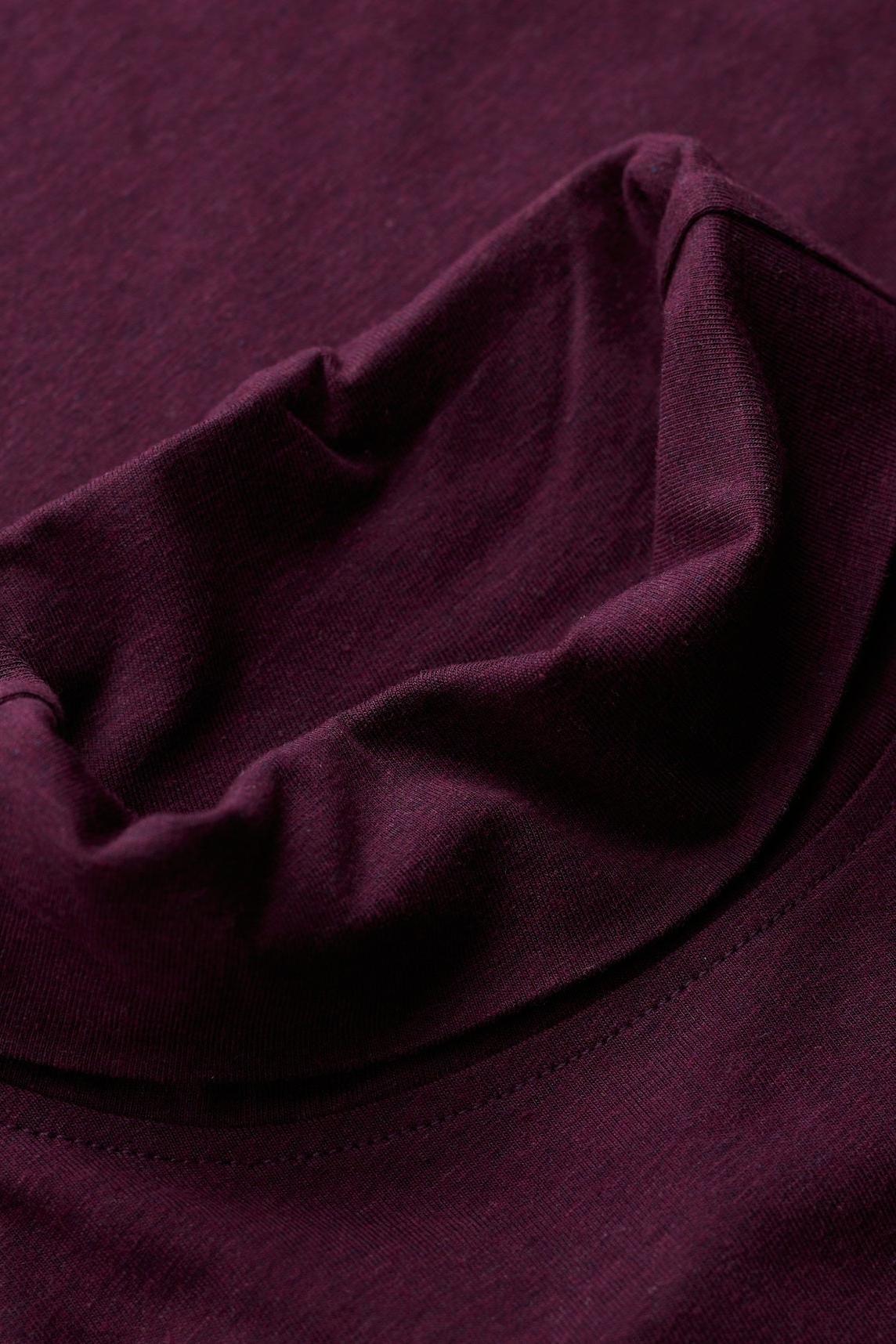 Close-up of a purple organic cotton roll neck shirt featuring a soft-textured turtle neck collar.