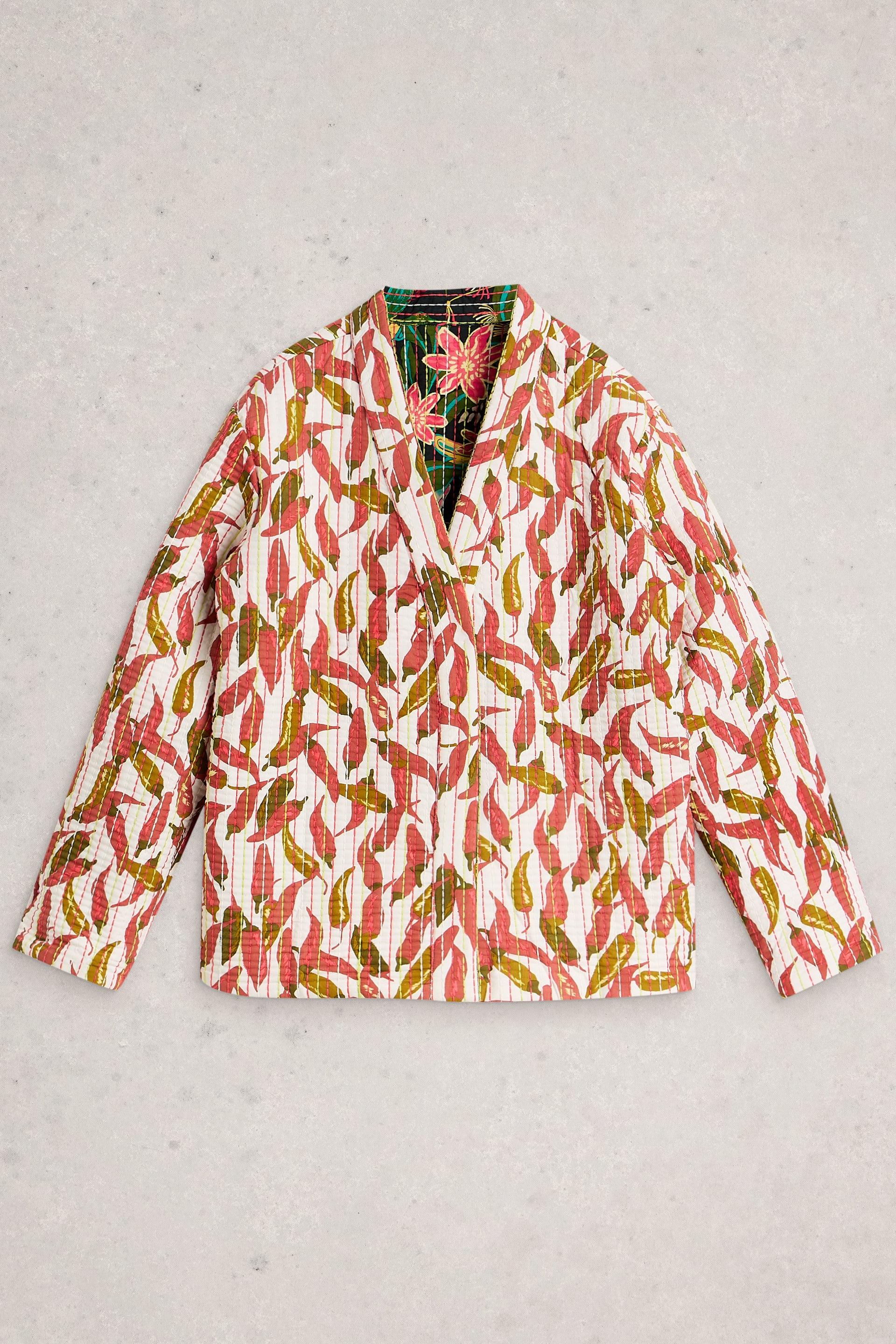 Quilted jacket with a red chili pepper print made from organic cotton on a light gray background.