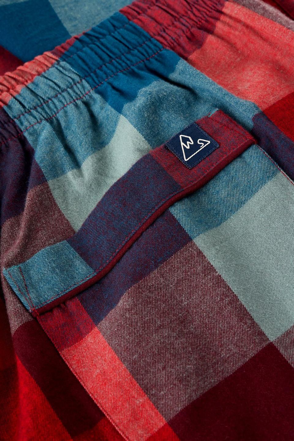 Close-up of red check organic cotton men's pyjama trousers with White Stuff branding