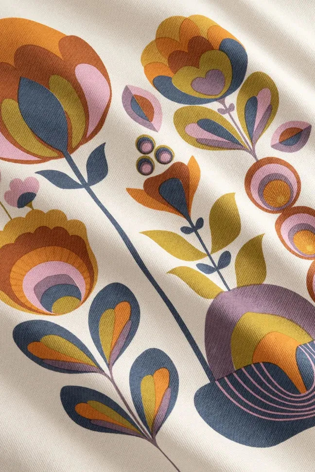 Close-up of a vintage-style floral print on a cream-colored cotton women's sweatshirt.