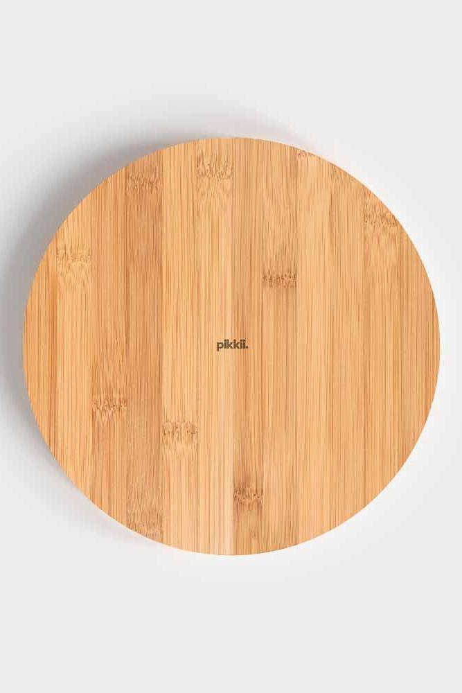 Round wooden cutting board with 'Pikkii' branding on a light gray background