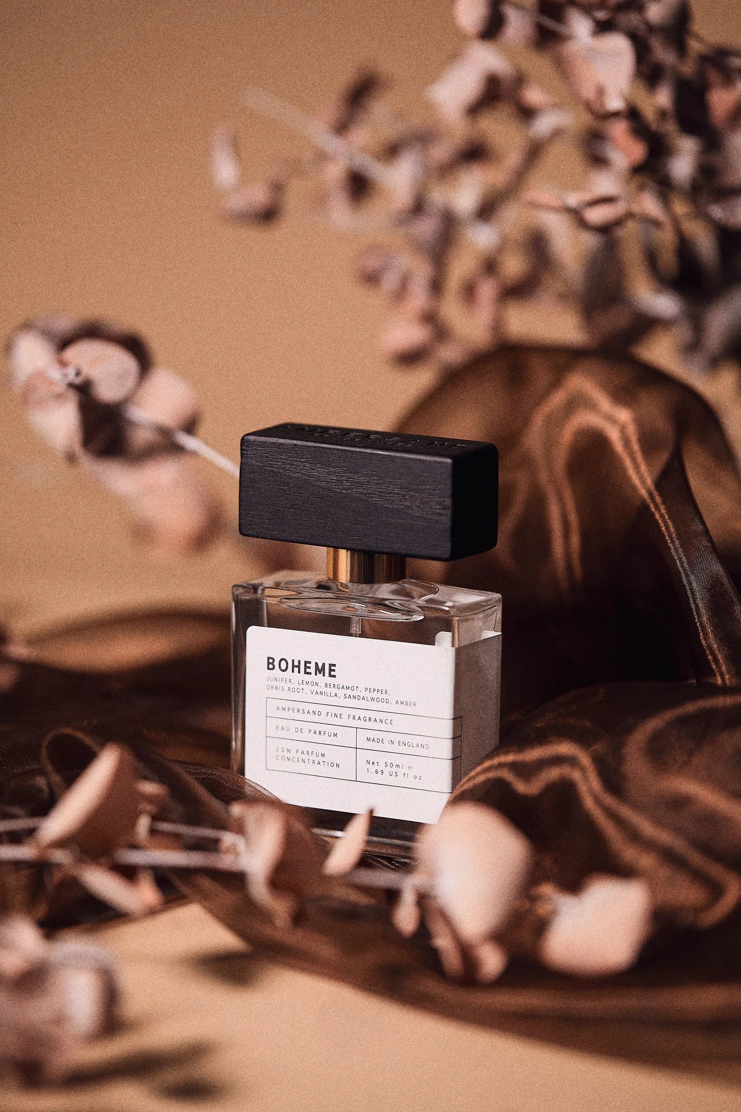 Ampersand perfume bottle labeled 'Boheme' with dried flowers on a warm-toned background.