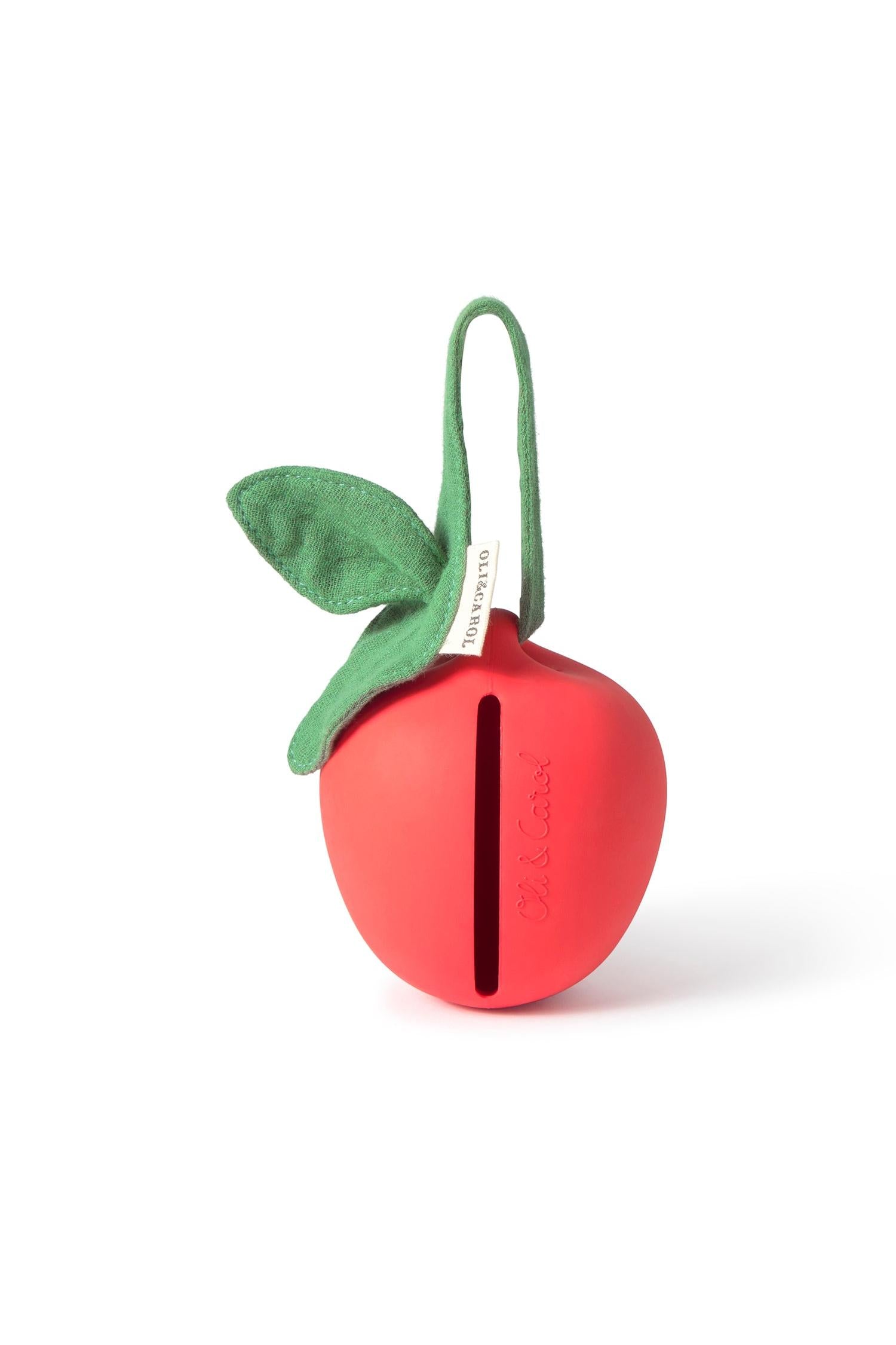 Red apple-shaped soother container with a green organic cotton leaf on a white background