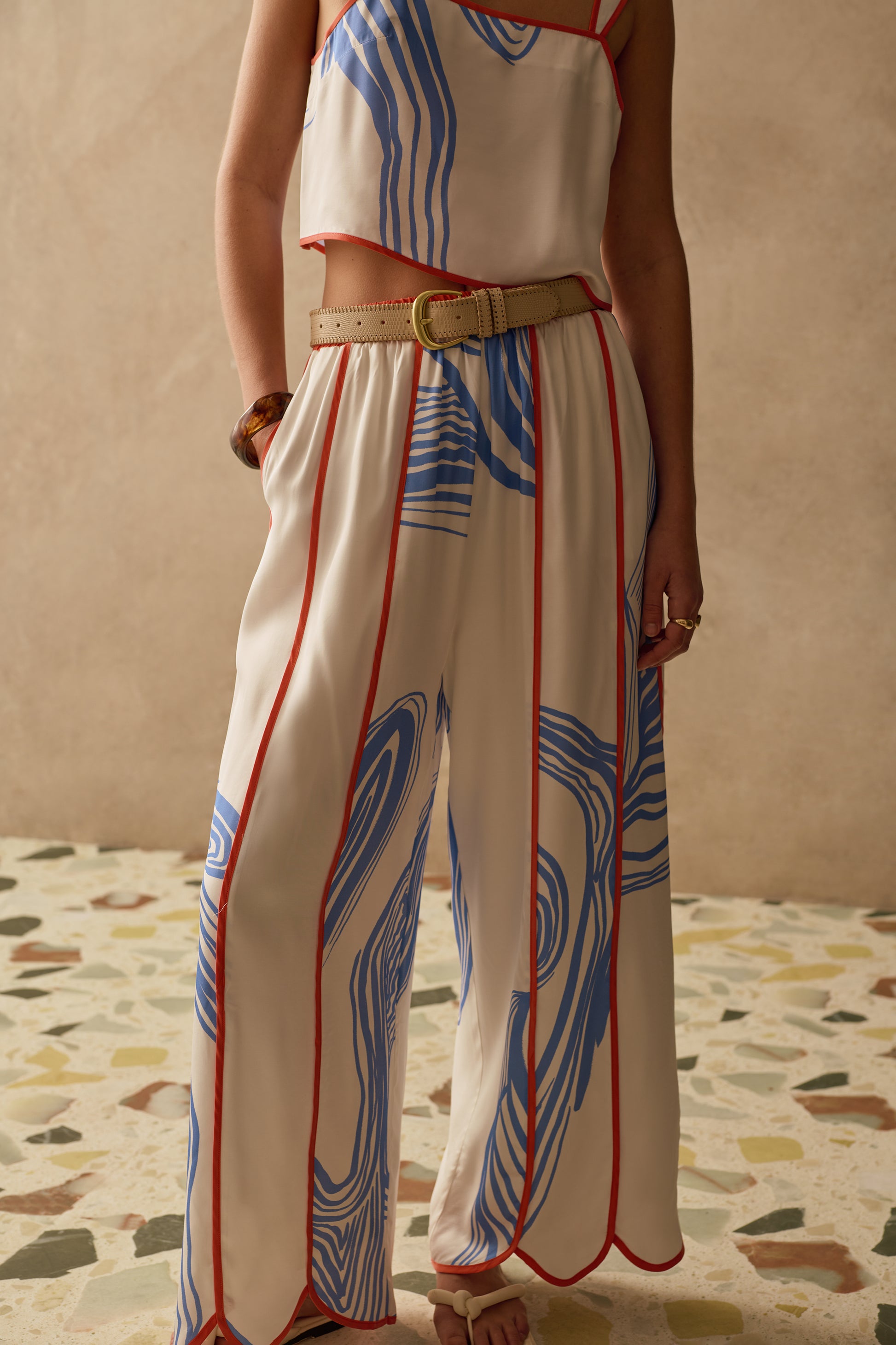 Person wearing a patterned Sancia outfit with a beige background