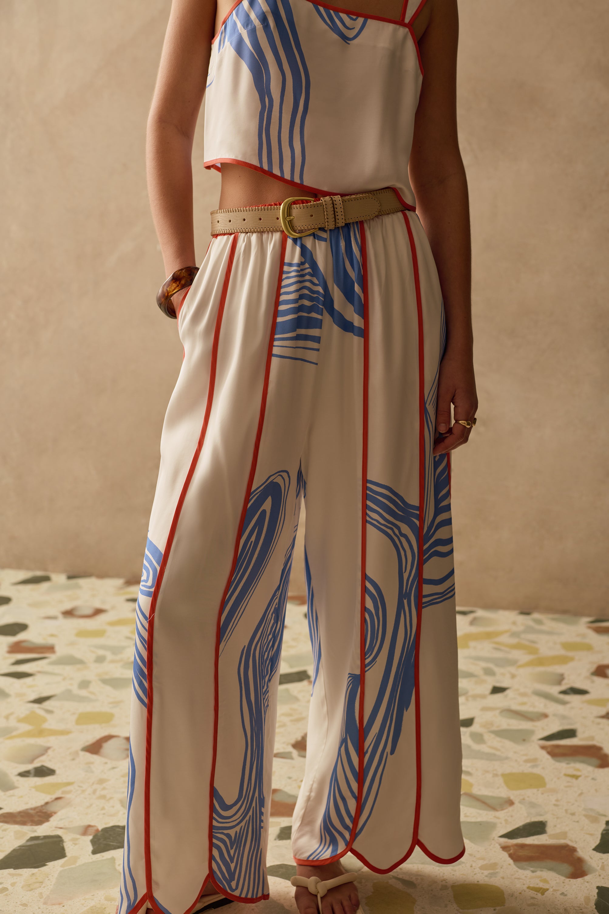 Person wearing a patterned Sancia outfit with a beige background