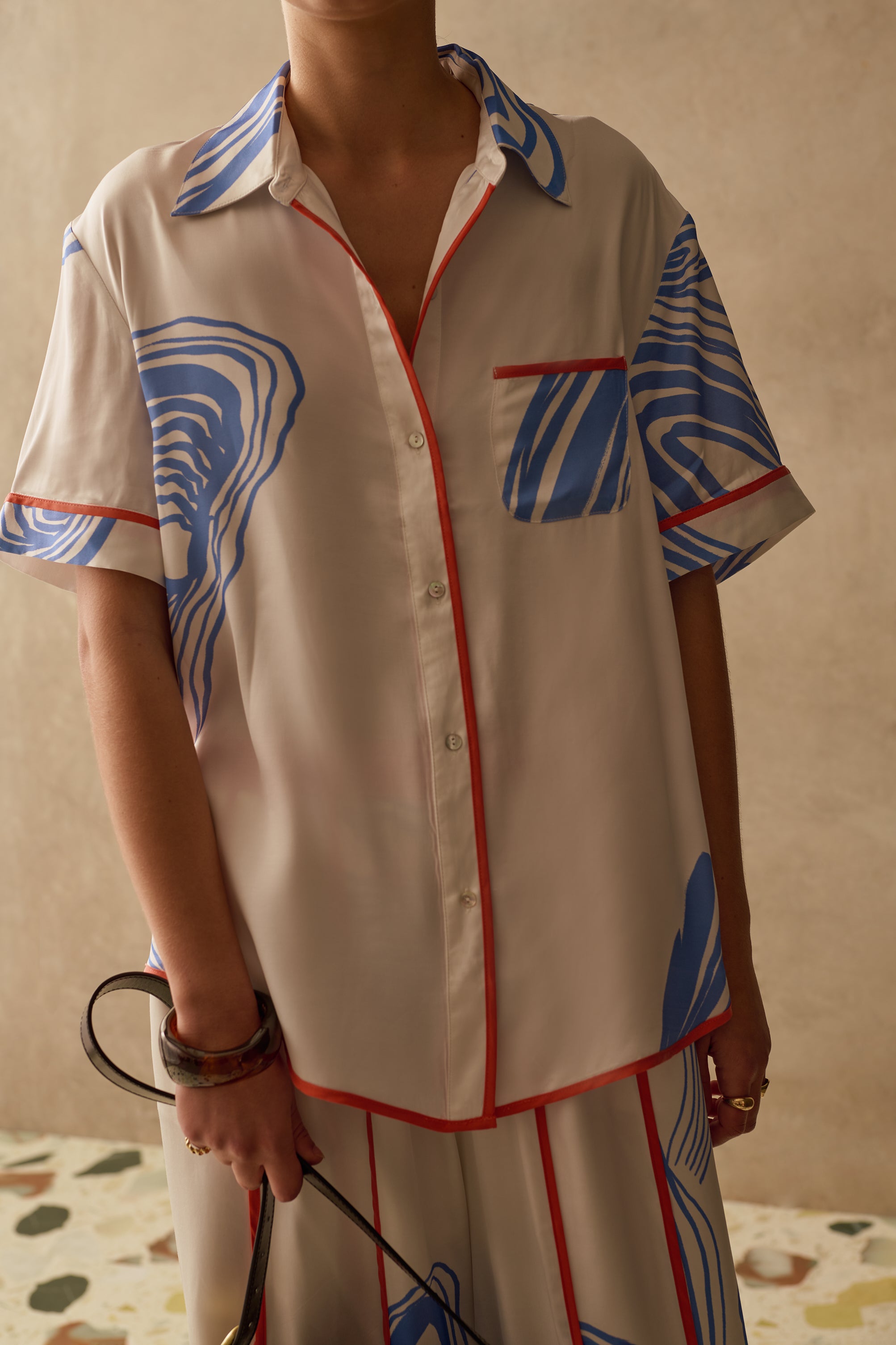 Model wearing a patterned relaxed summer shirt with buttons and front pocket