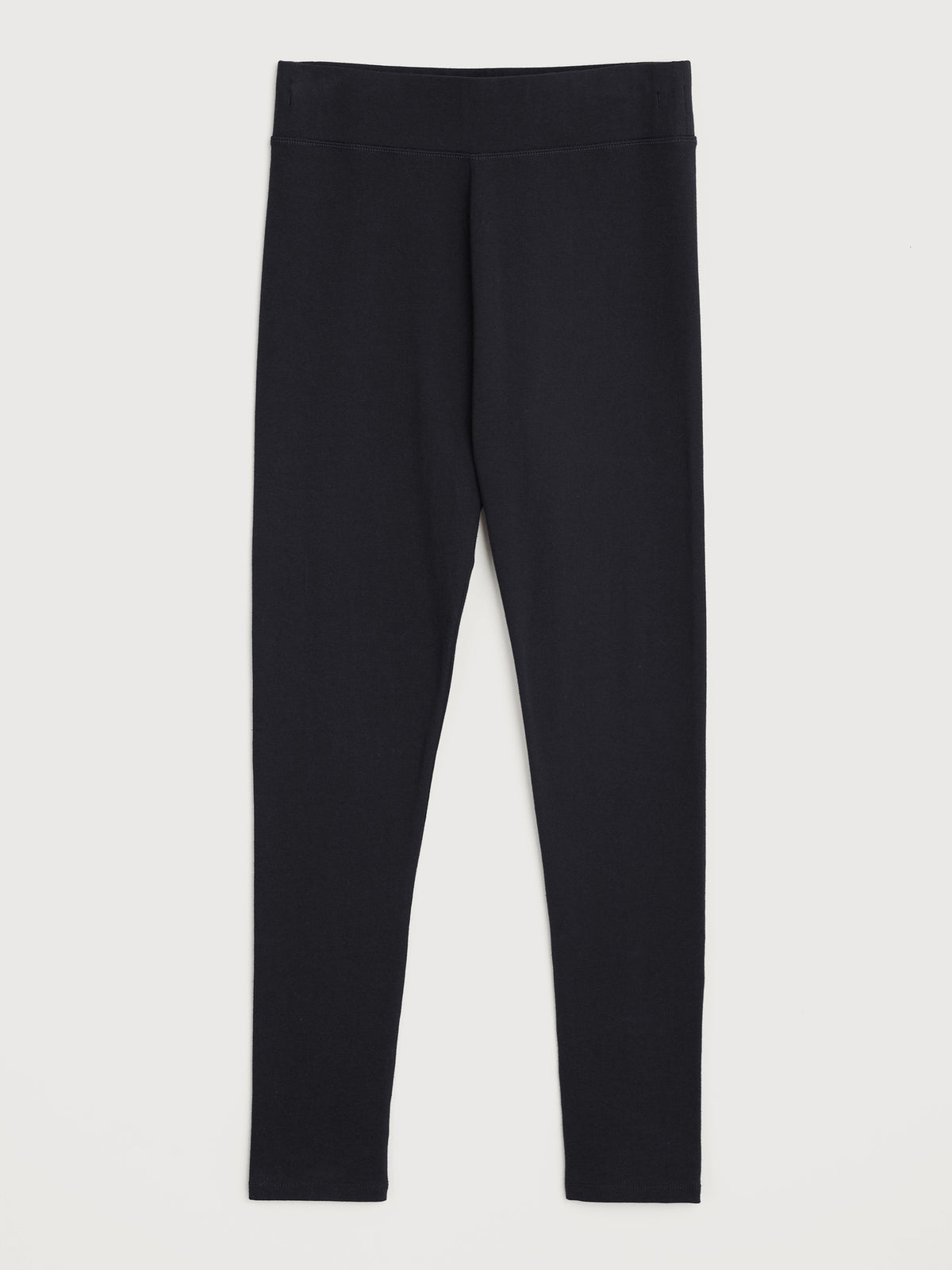 A pair of plain black women's leggings made from organic cotton against a neutral background.