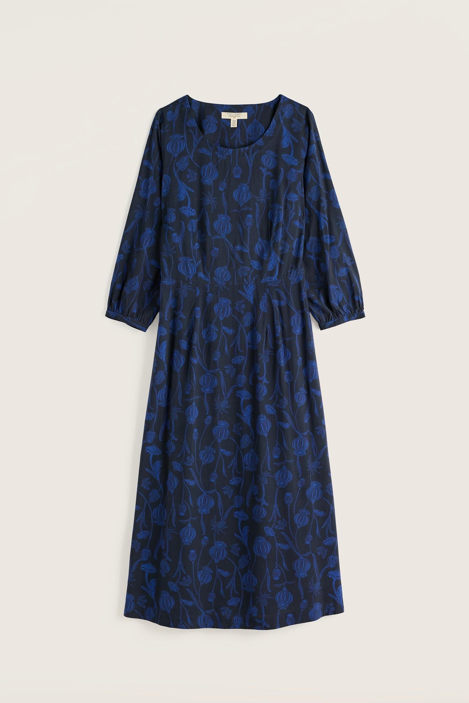 A navy blue midi length dress with a floral pattern by Seasalt Cornwall against a plain neutral background.