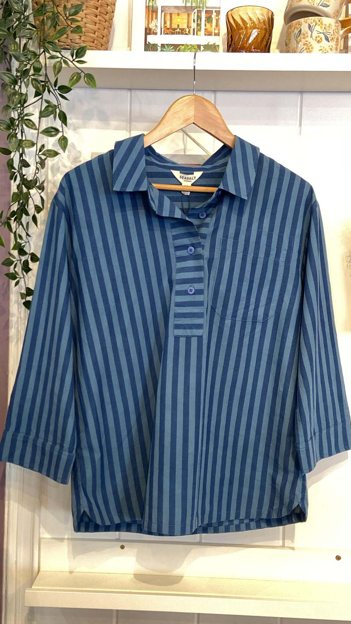 Seasalt Cornwall women's blue stripe cotton shirt hanging on a wooden hanger