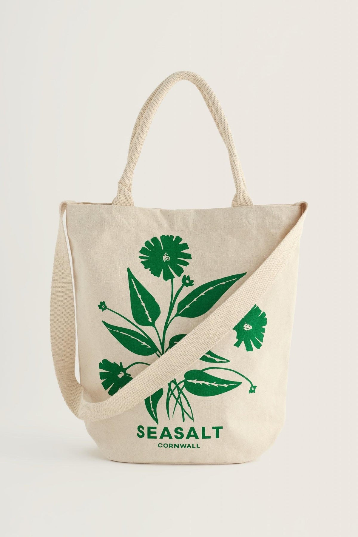 A natural canvas shopping tote bag by Seasalt Cornwall featuring a green floral spring print design.