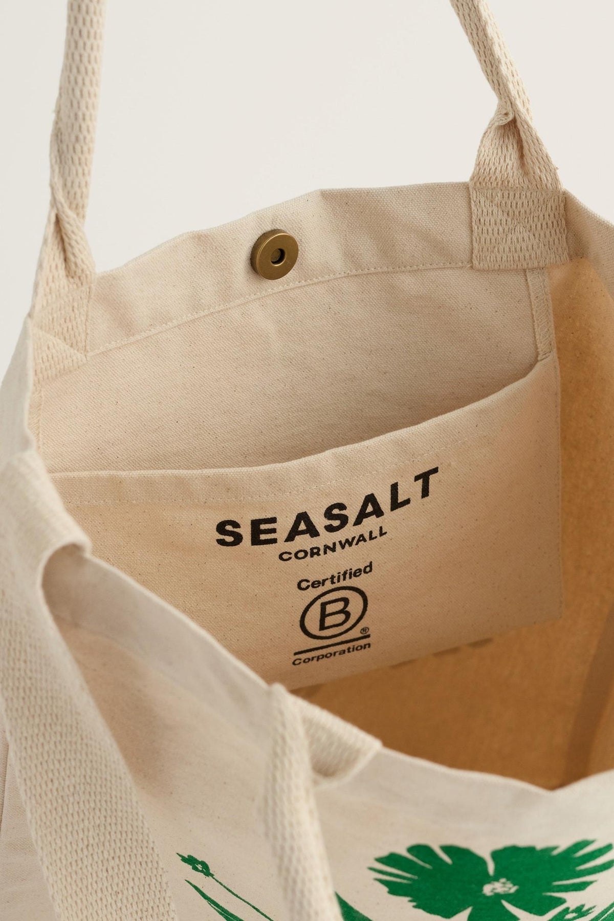 Interior view of a Seasalt Cornwall canvas tote bag with a B Corp logo on the inner pocket.